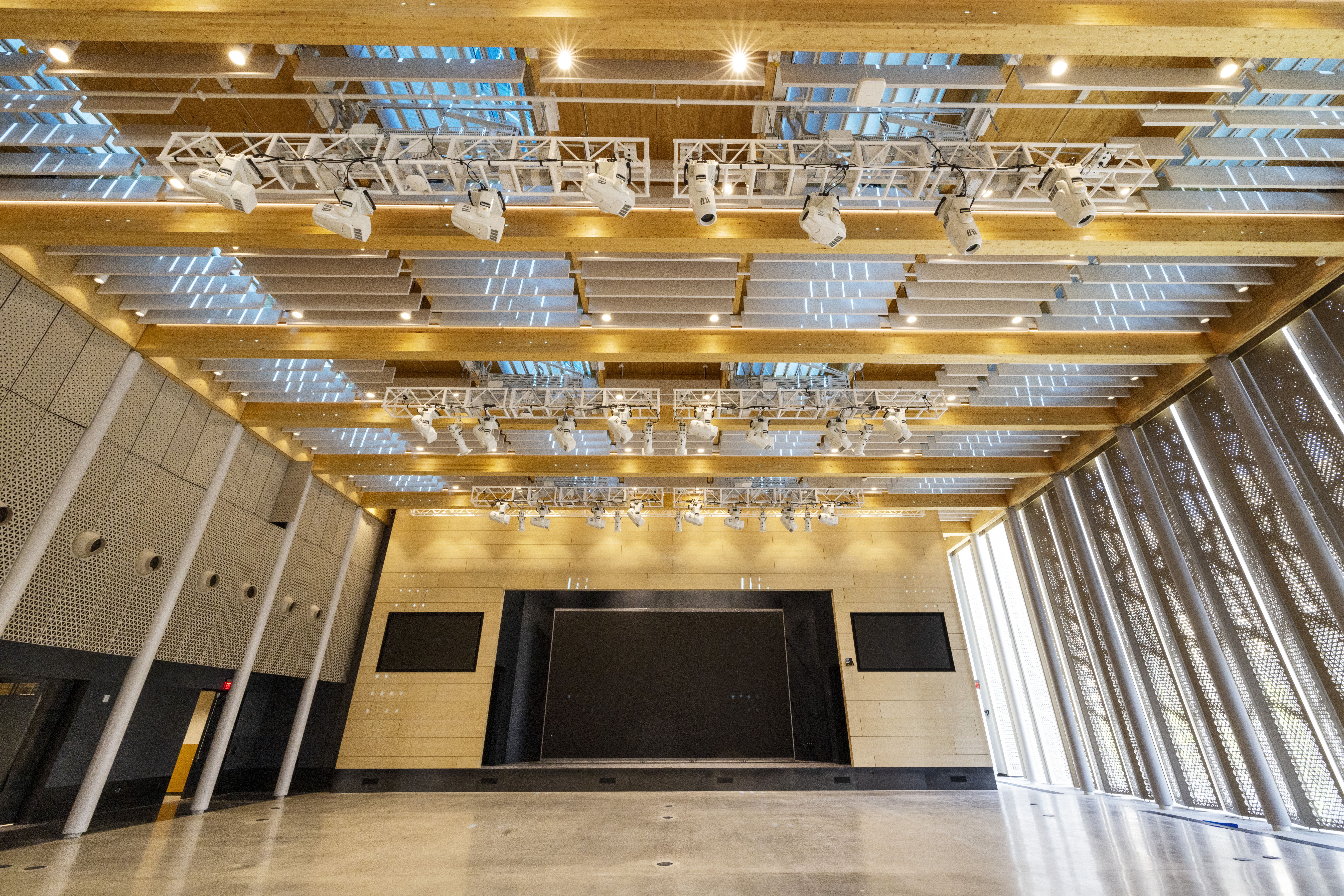 A large auditorium space inside with light colored wood panels