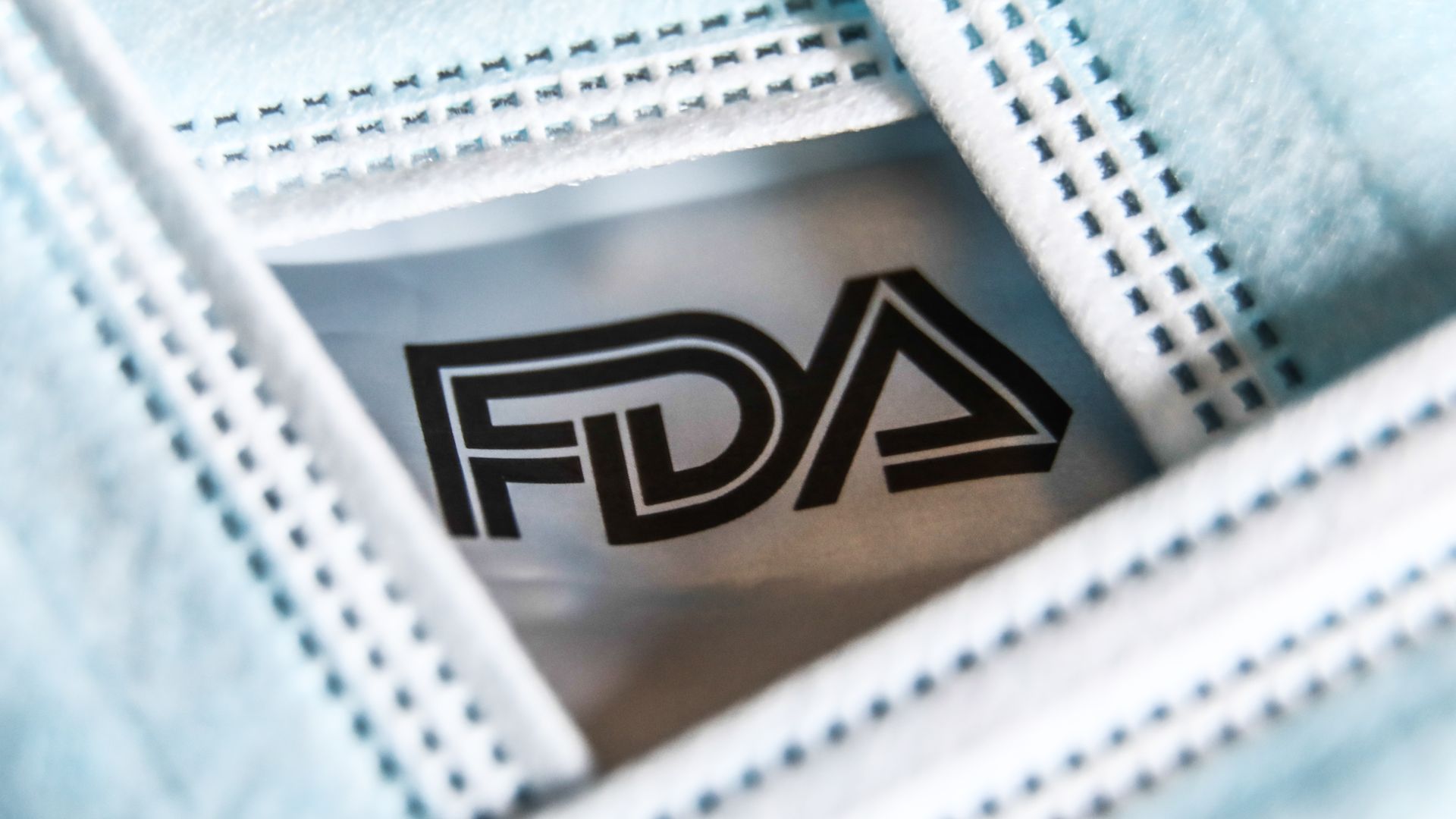 The FDA logo framed by face masks.