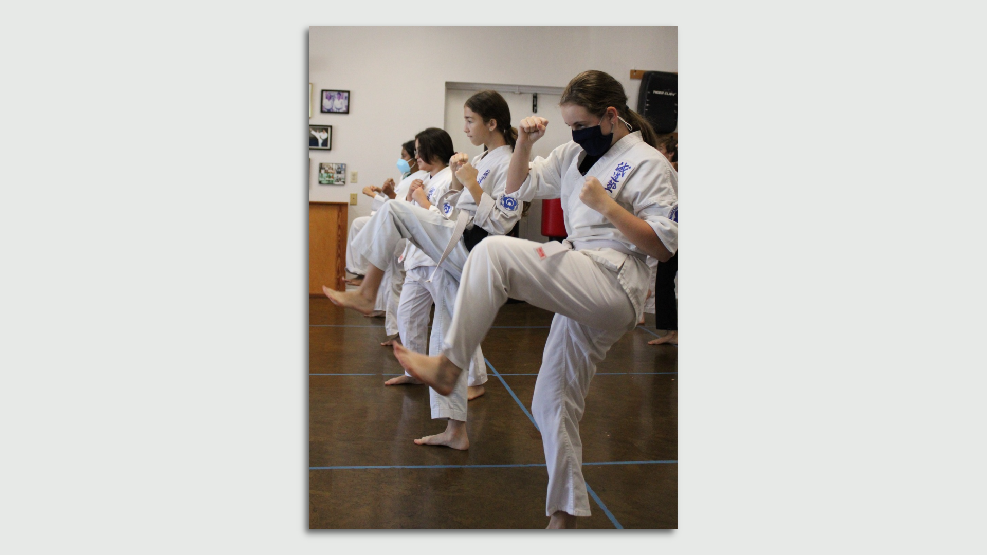 Students kicking at a martial arts studio.