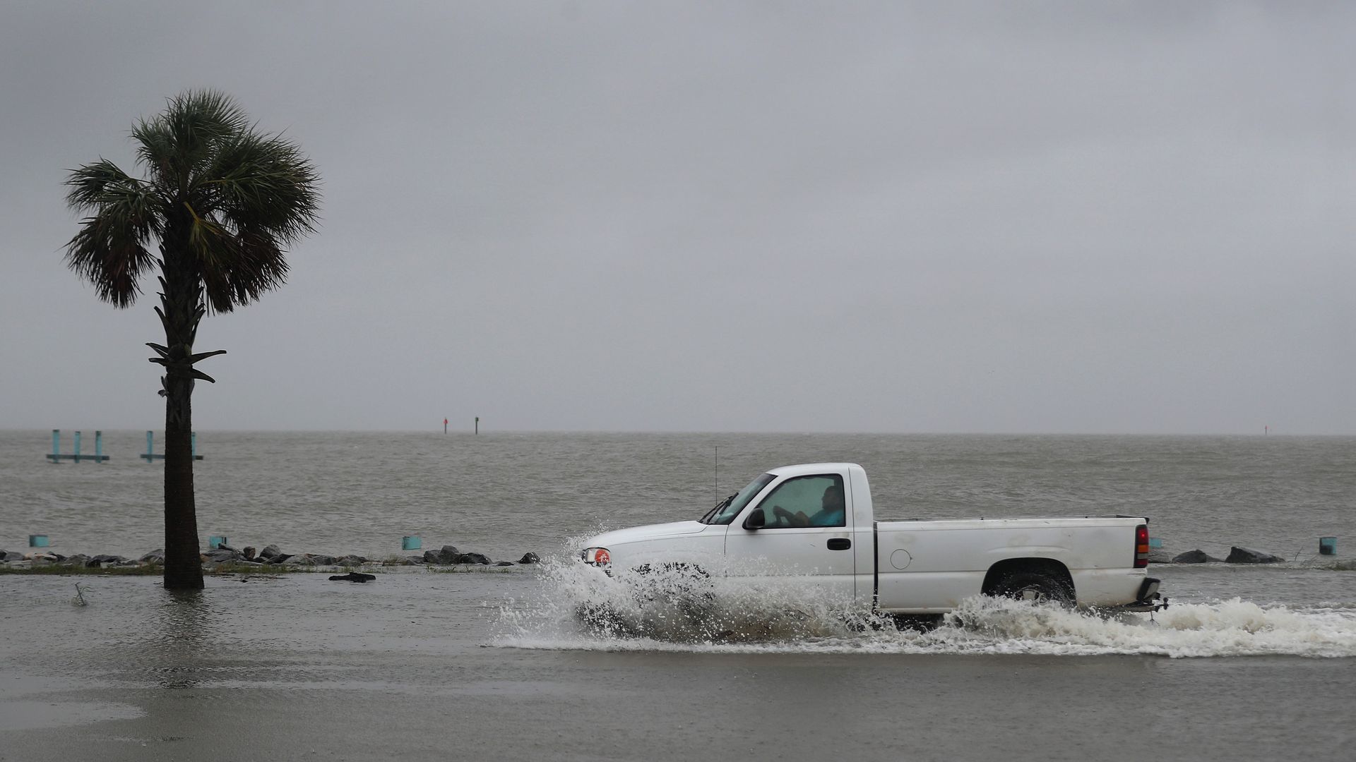 A driver navigates along a flooded road as the outer bands of Hurricane Sally come ashore on September 15, 2020 in Bayou La Batre, Alabama. 