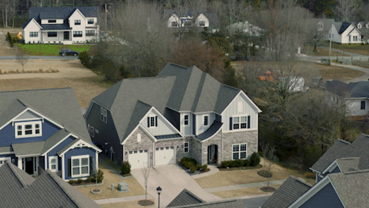 A drone delivers a Walmart box in front of a house