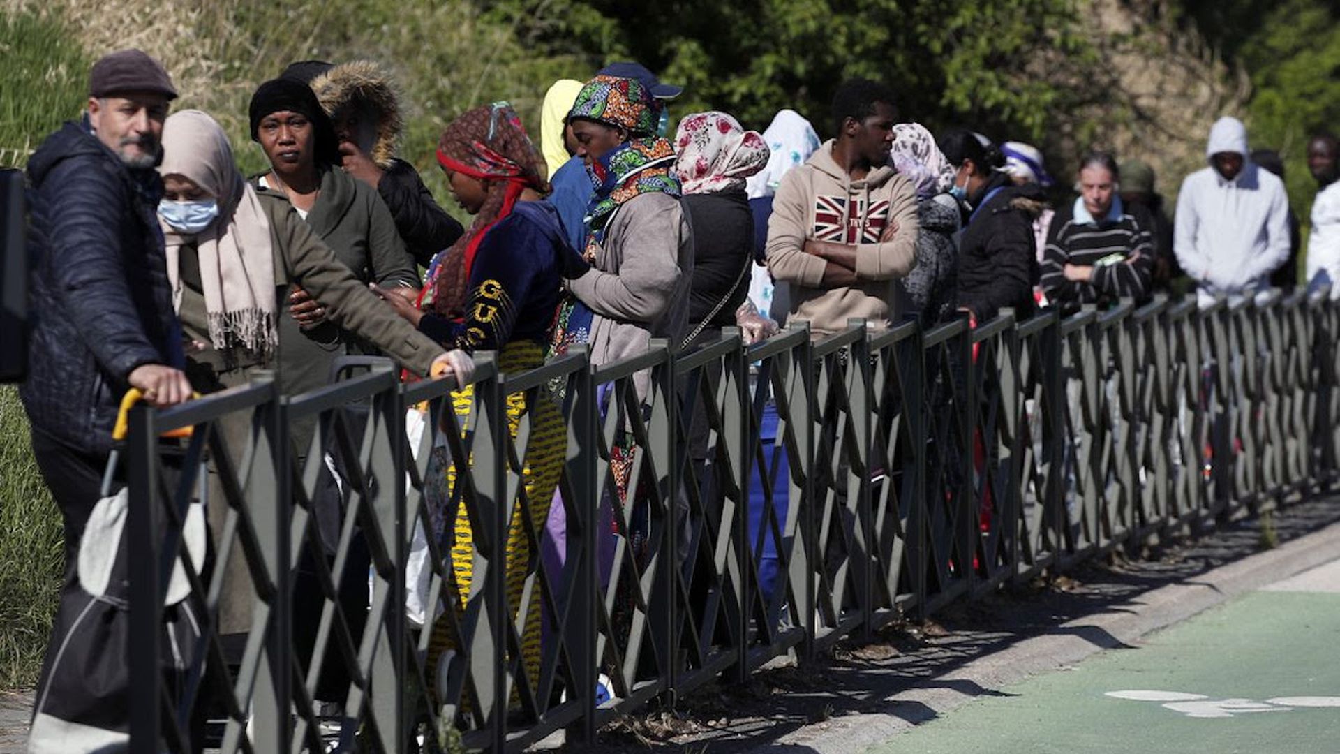 People line up for food in Clichy-sous-Bois, a suburb north of Paris. Open-air markets closed, supermarket prices are skyrocketing and people are out of jobs. 