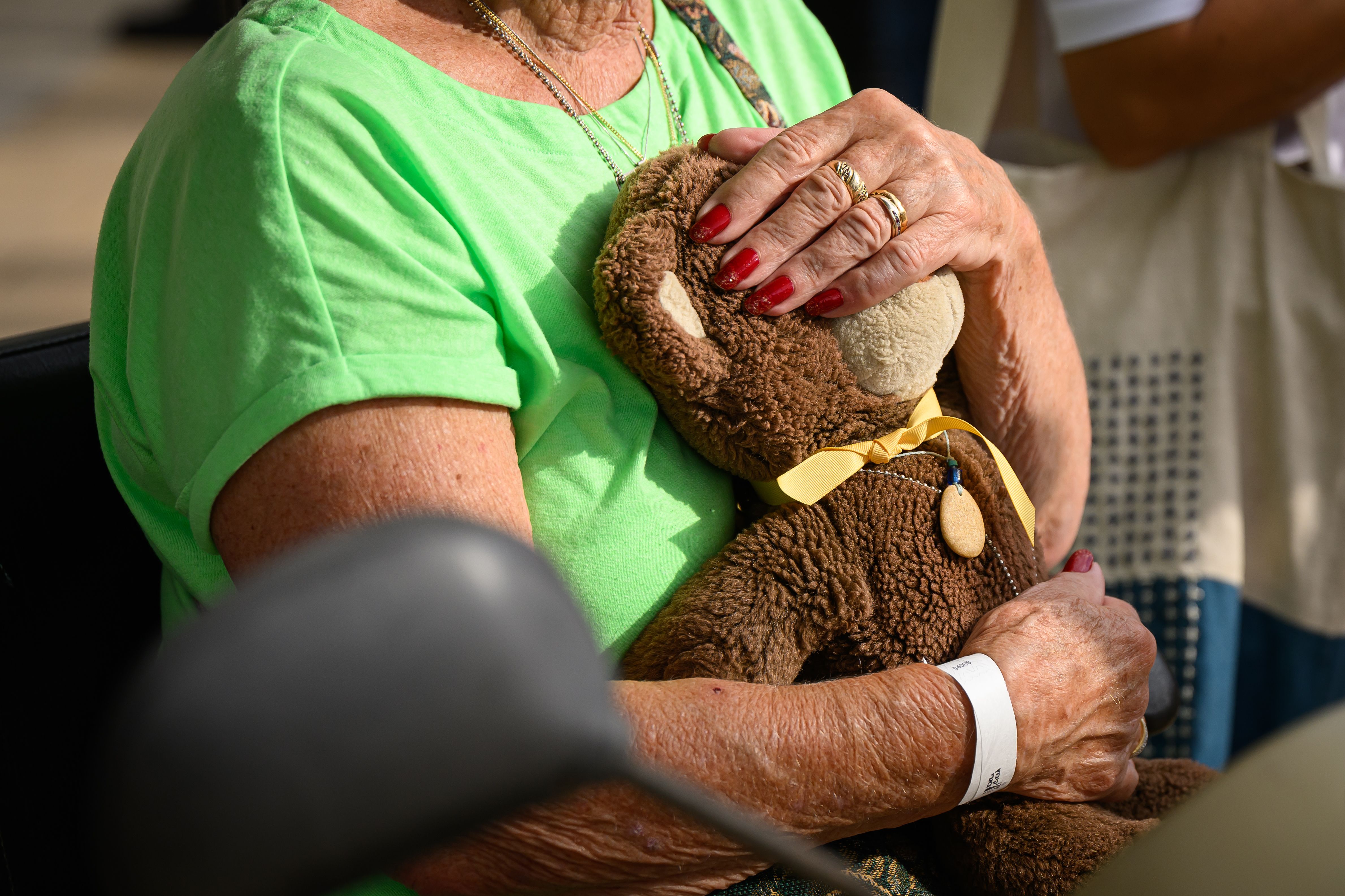 A close up photo of a woman holding a teddy bear. 