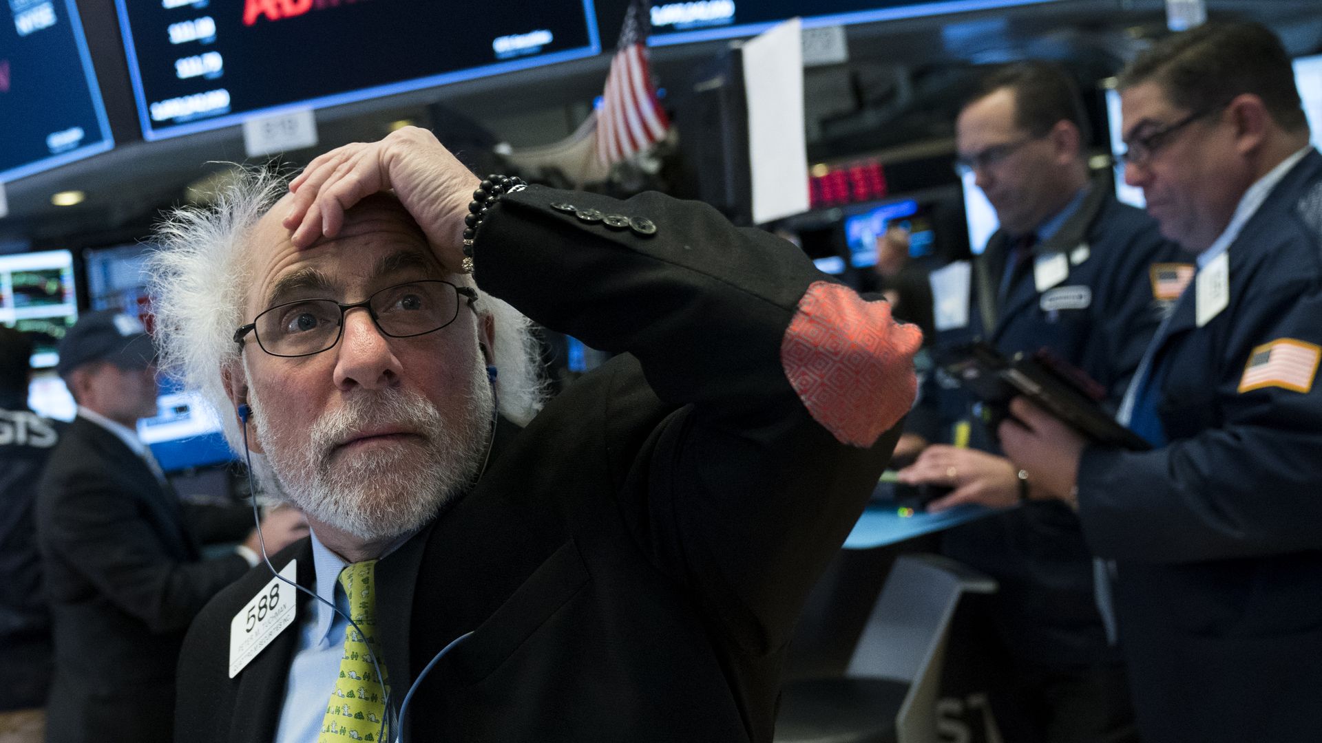 A photo of a trader on the floor of the New York Stock Exchange looking shocked.