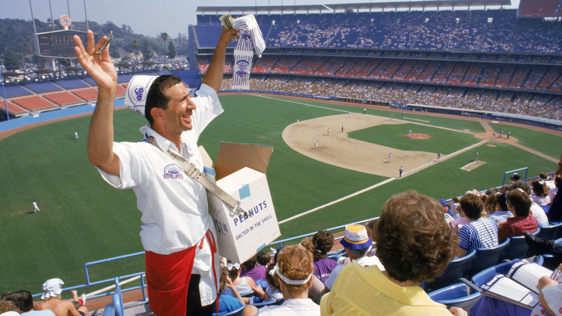 A man delivering peanuts at a baseball game.