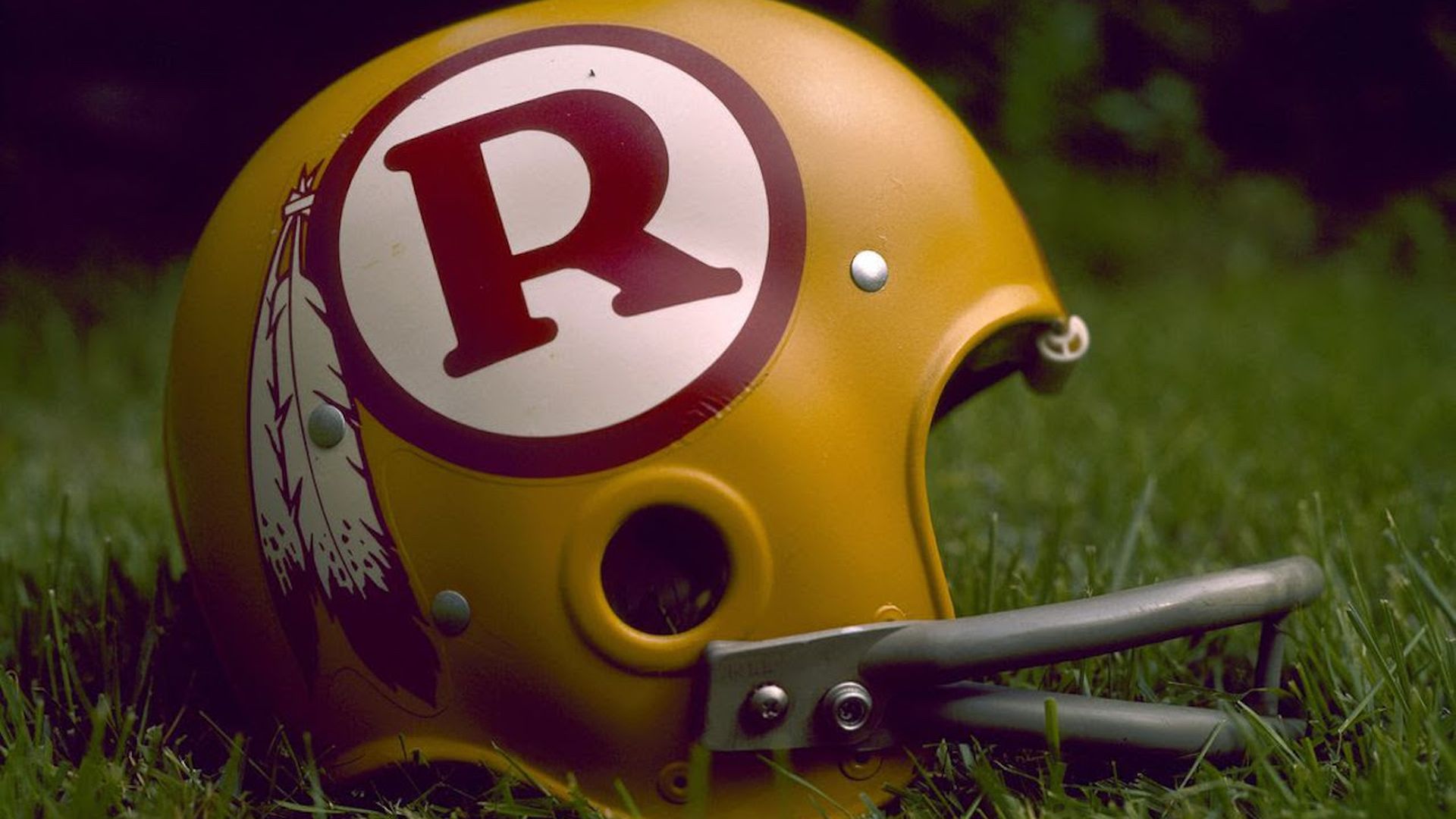 A vintage Redsins football helmet in some grass