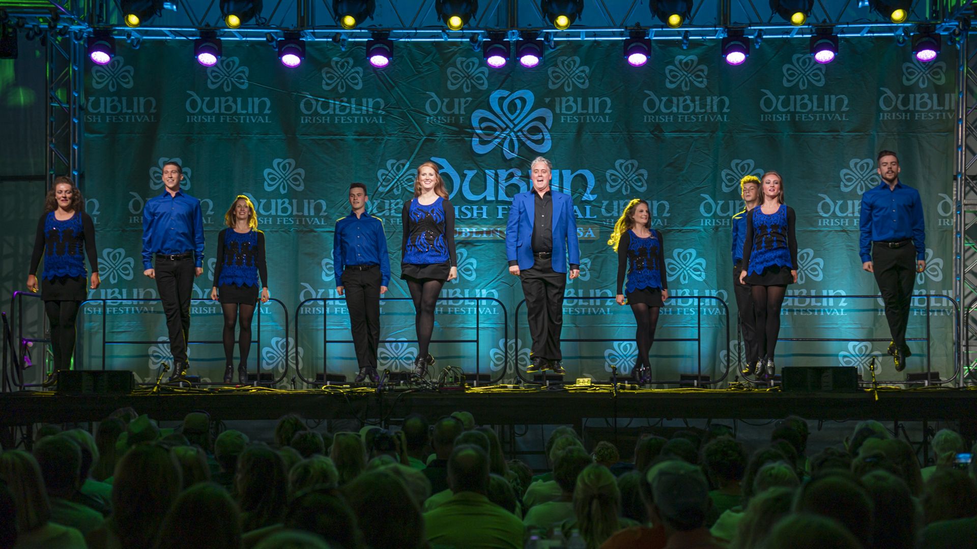 Celtic dancers lined up on a Dublin Irish Festival stage in front of a large crowd