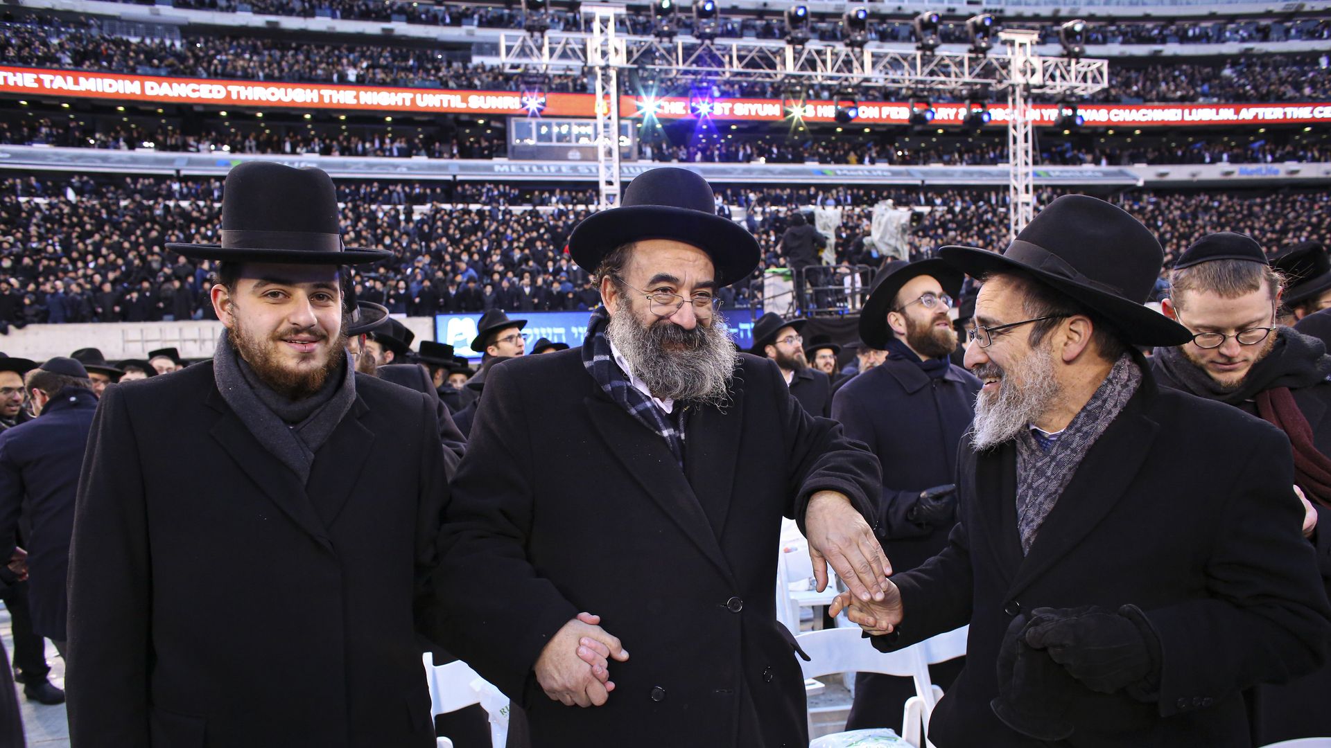 Men dance as they gather with others in MetLife Stadium on January 1, 2020, in East Rutherford, New Jersey