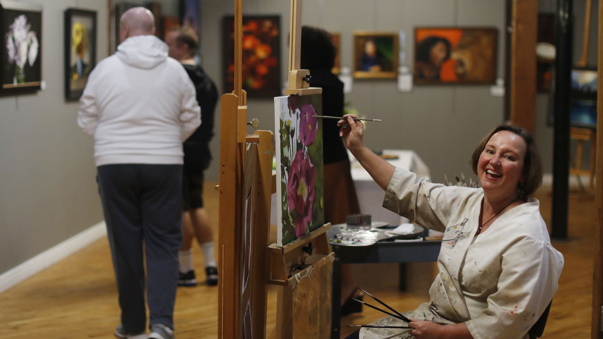 A woman painting in the middle of an art store.