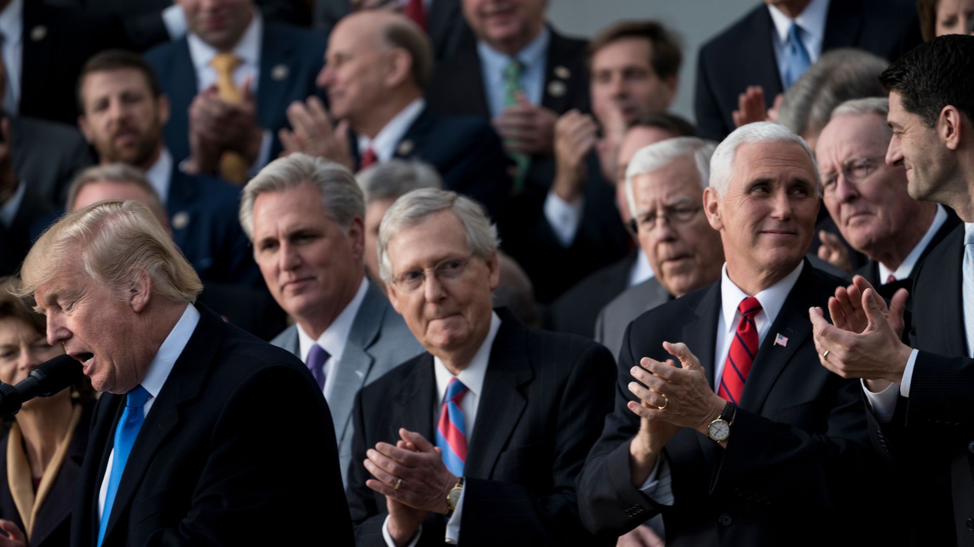 Republican male leaders clapping after passing tax cuts