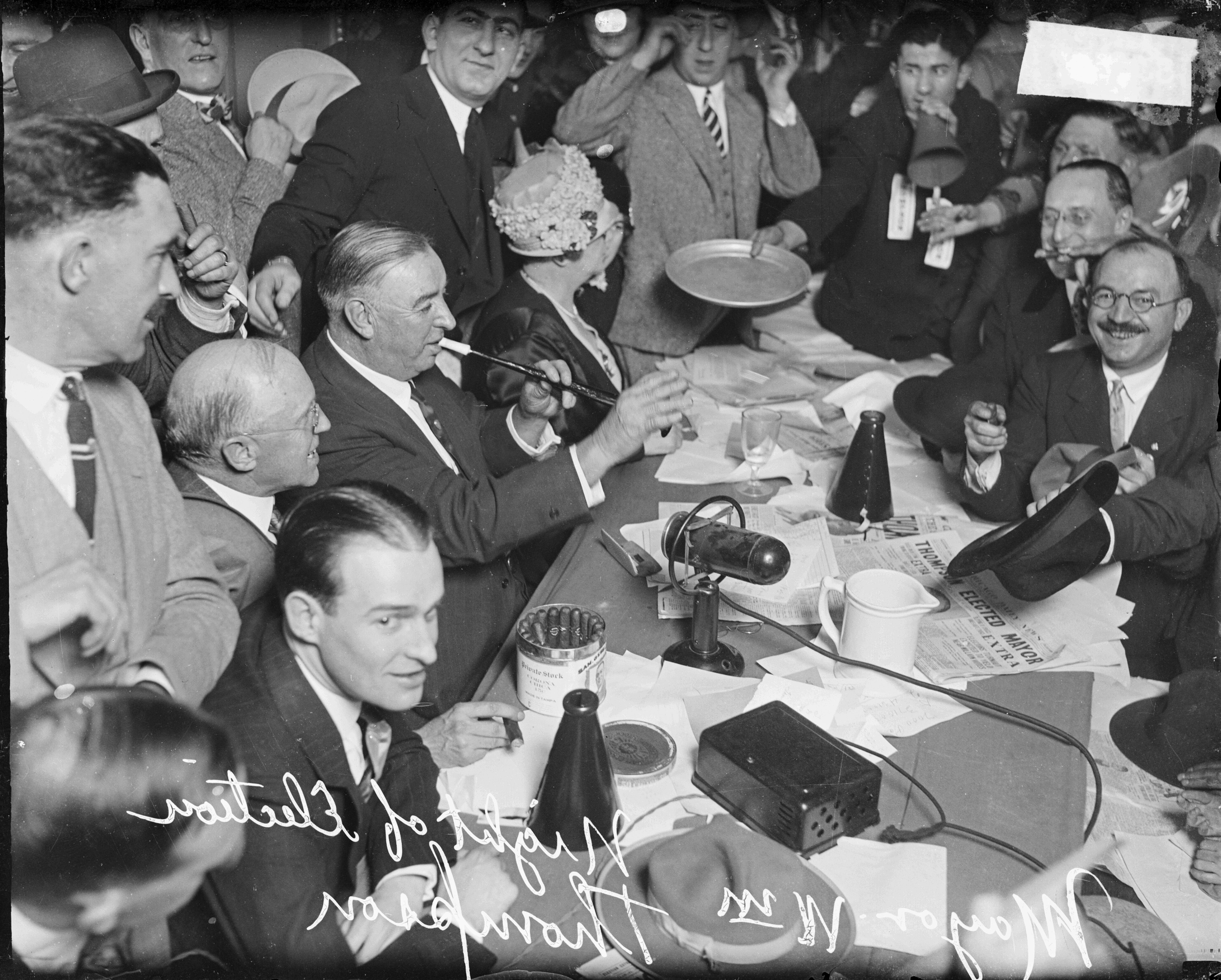 Photo of men sitting around a table celebrating 