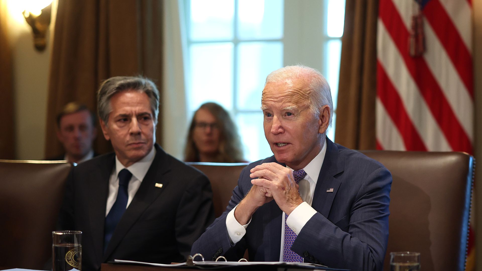 President Biden sits in a brown chair at a Cabinet meeting, with Secretary of State Antony Blinken. left. 