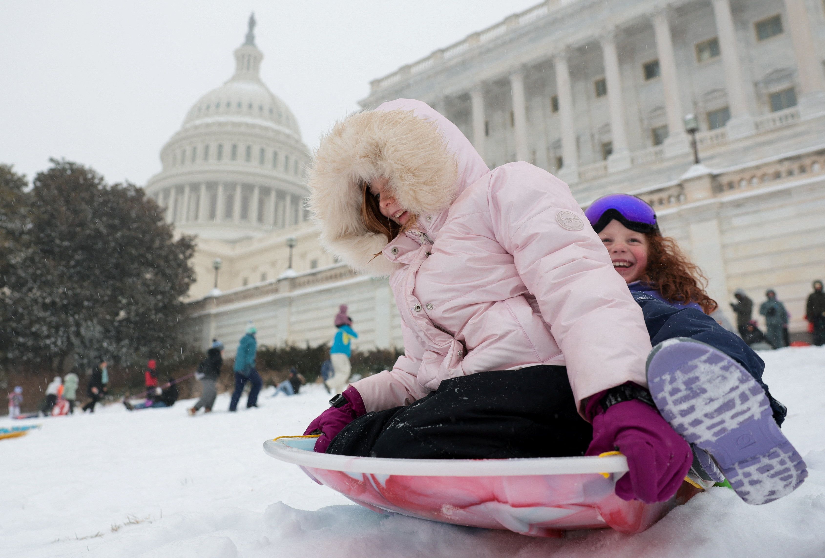 Children sled near the U.S. Capitol building as a major winter storm spreads across a large swath of the United States, in Washington, D.C., U.S., January 25, 2026. 