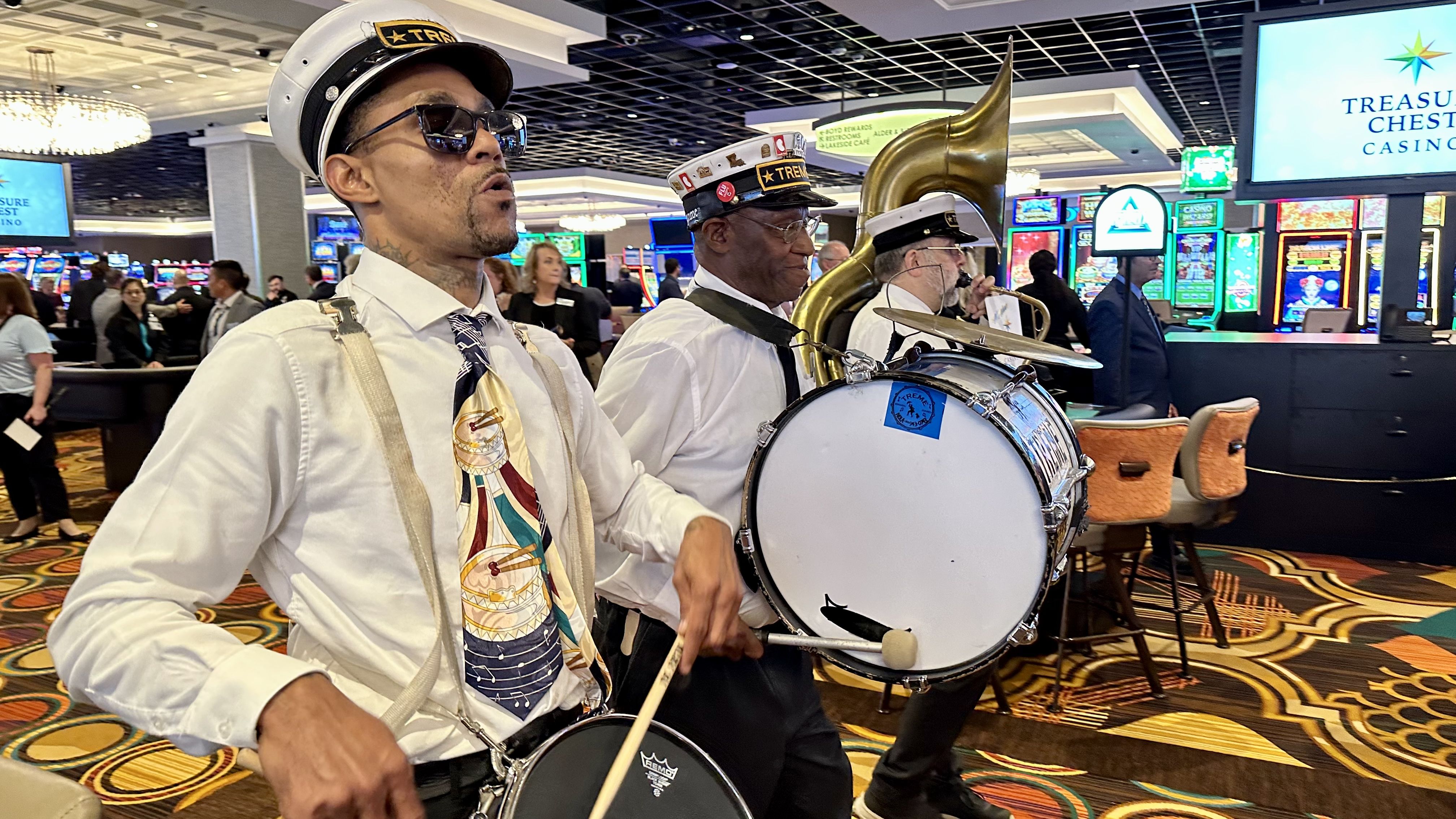 Photo shows brass band players marching through the casino floor.