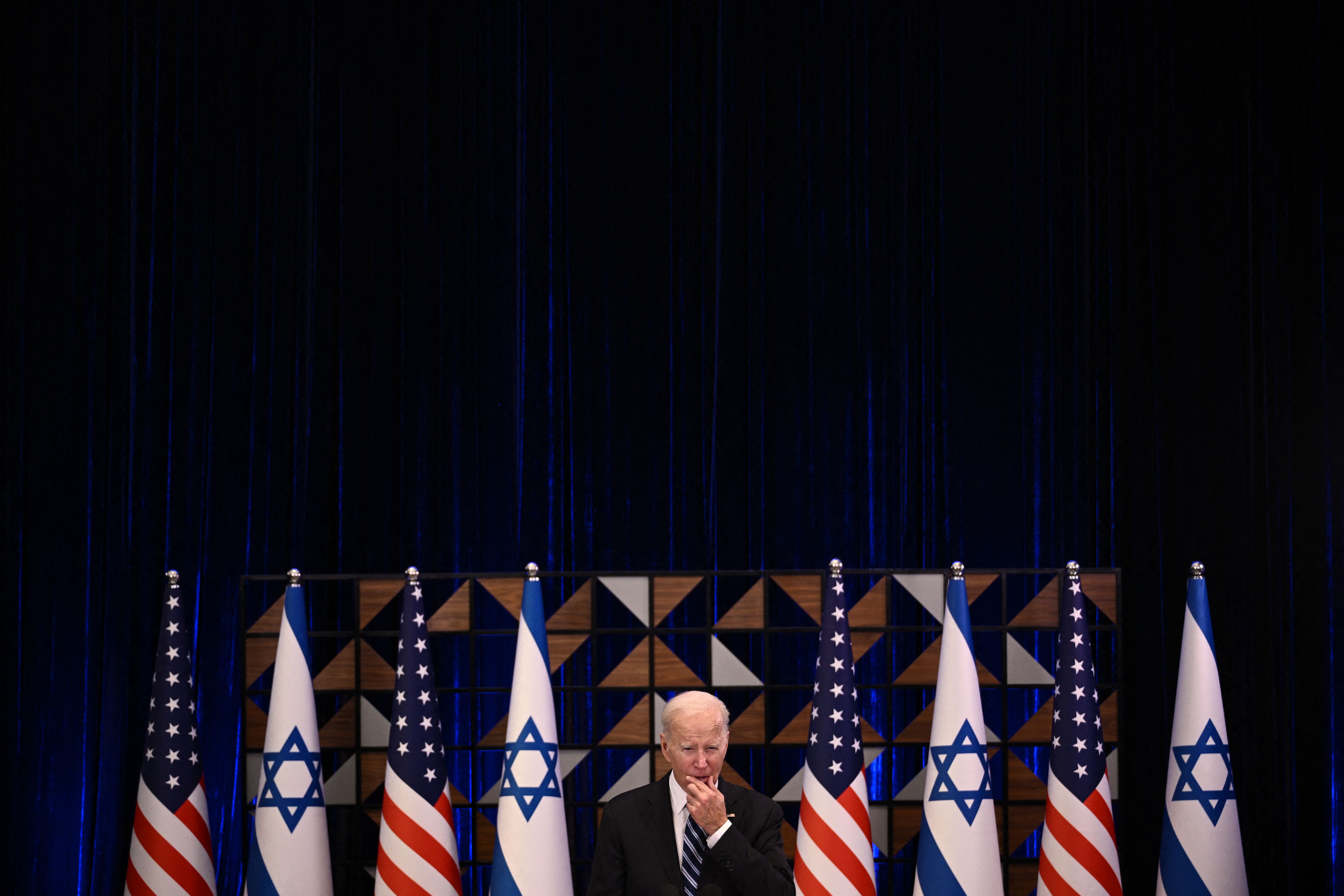 U.S. President Joe Biden standing in front of a row of flags alternating between U.S. and Israeli flags. 