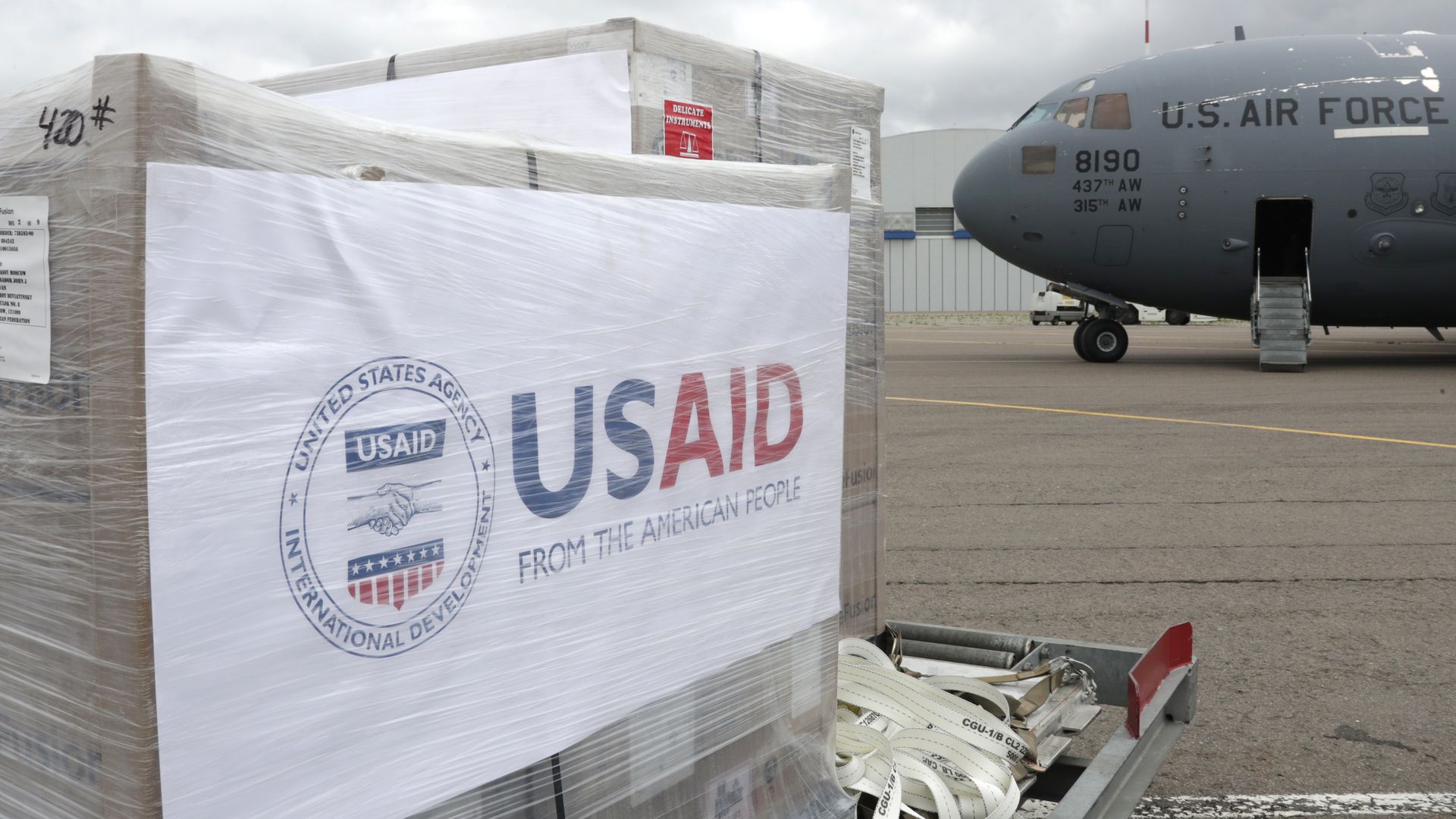 A plane sits on an airport tarmac with relief supplies.