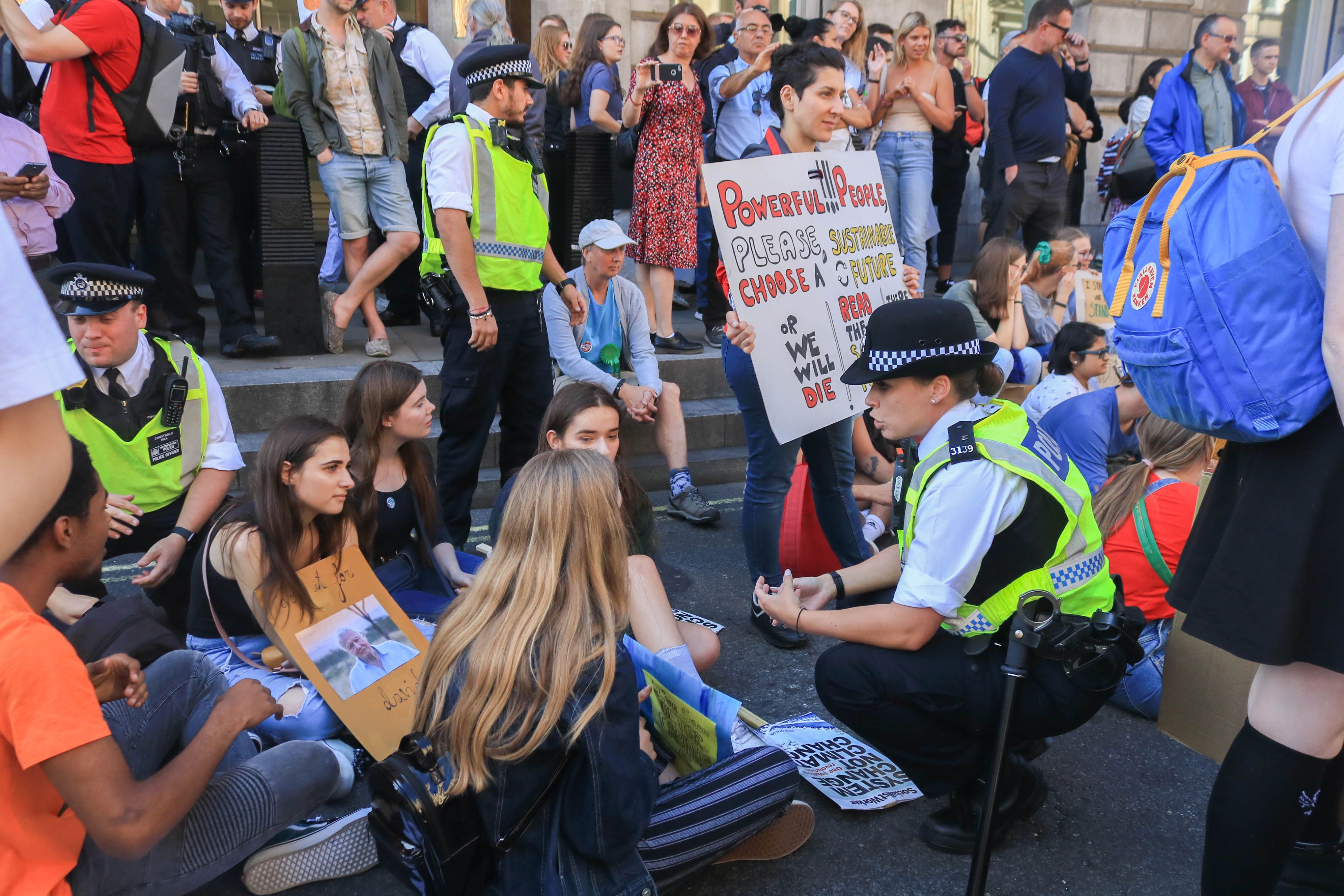 Climate activists block Whitehall during a protest sit in as thousands of students in London