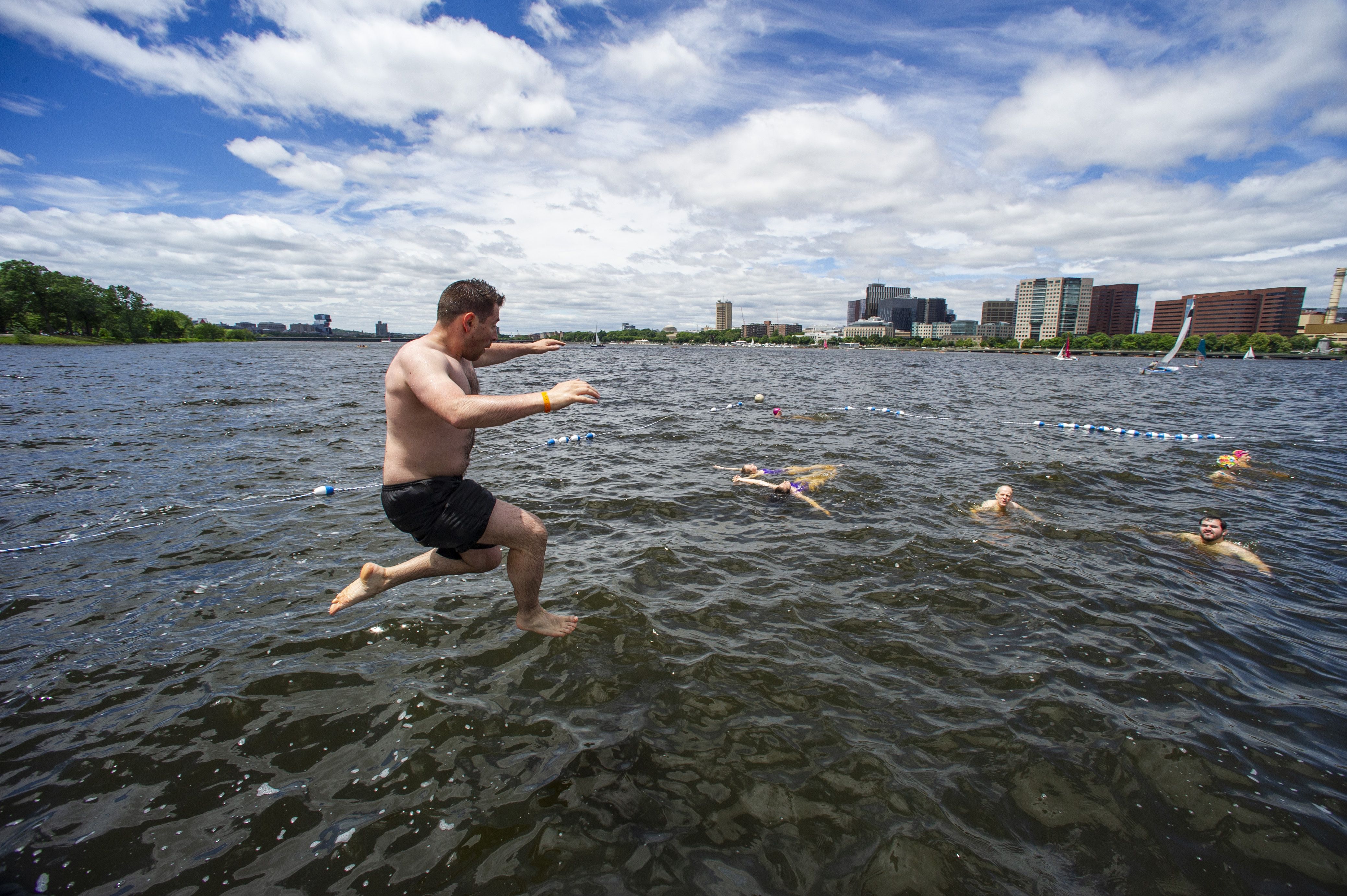 People jump off the dock and into the river during the 6th annual Charles River Conservancy and Charles River Swimming Club's City Splash in the Charles River in Boston on June 18, 2022