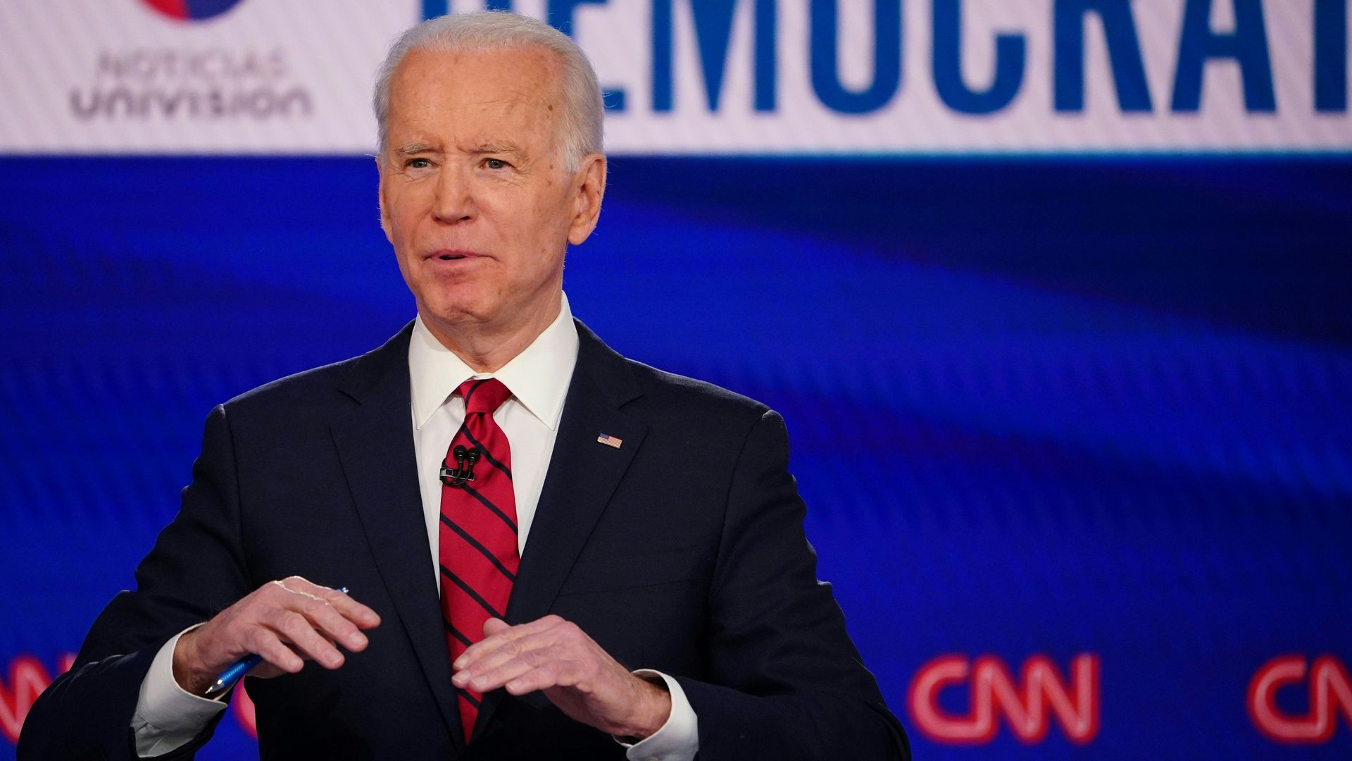 In this image, Biden stands on a debate stage and talks