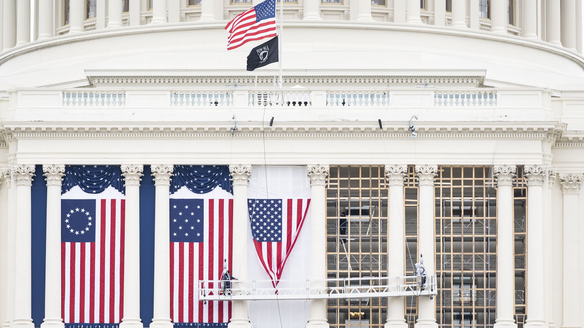 orkers hang the flags on the West Front facade in preparation for President-elect Joe Bidens inauguration at the Capitol