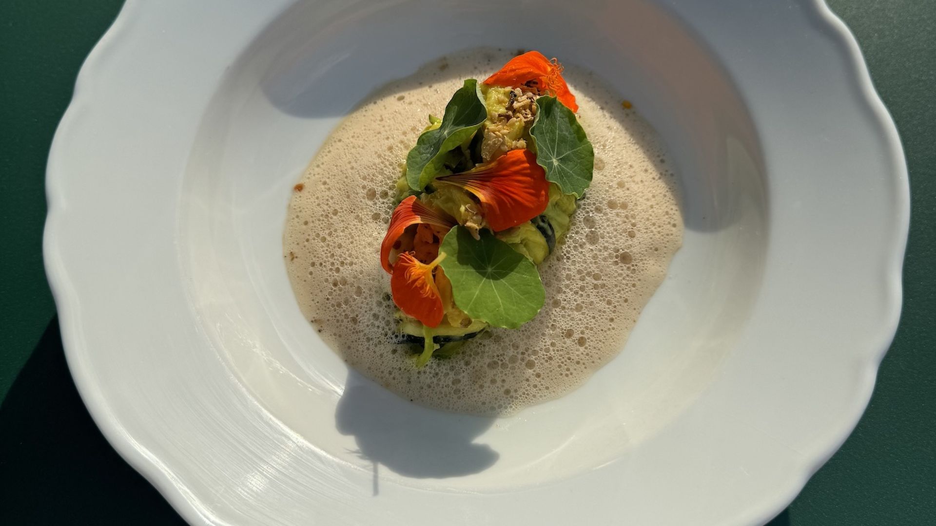 Tagliatelle pasta topped with flowers in a white bowl