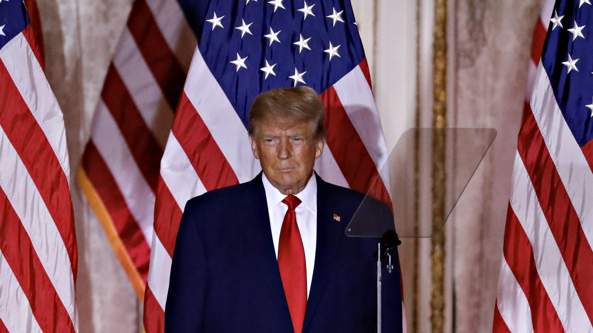 Donald Trump stands in front of U.S. flags as he speaks at a 2024 campaign event in Florida. 