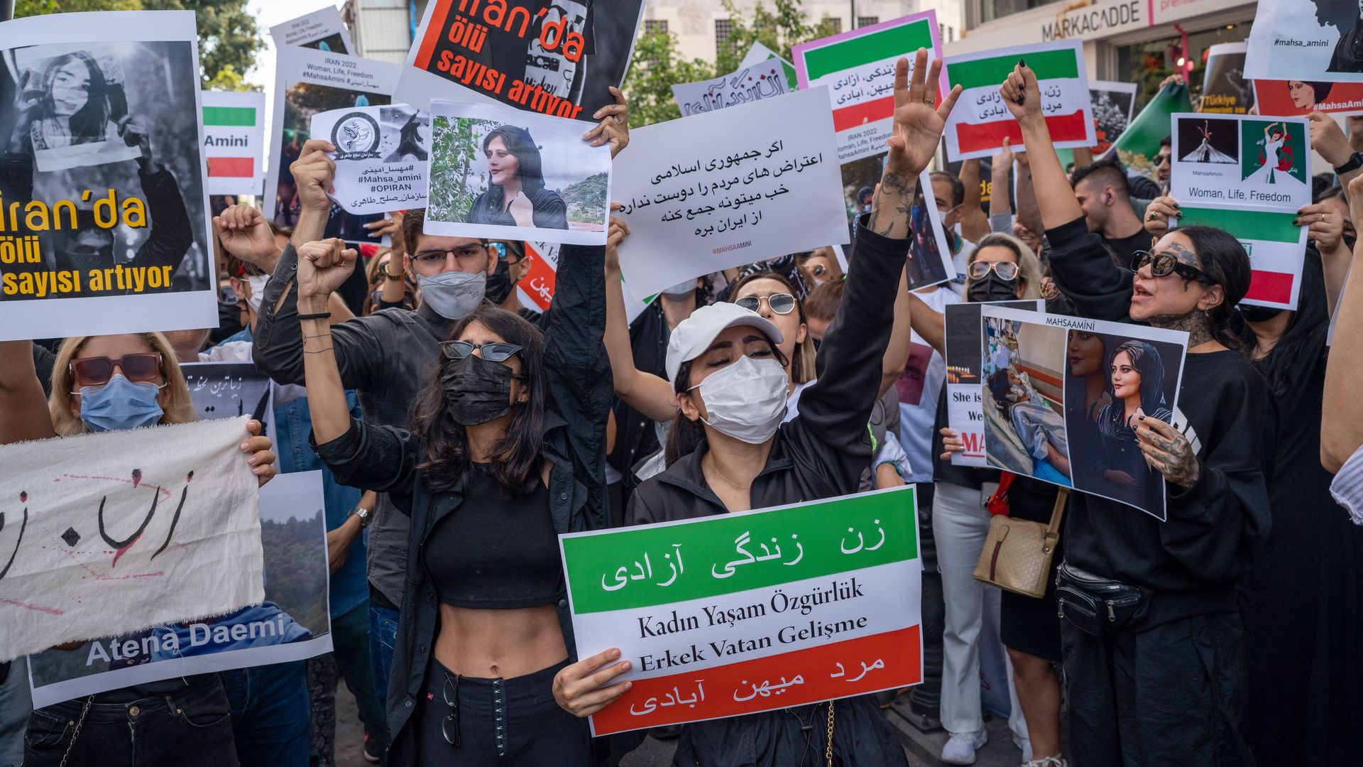 Protesters hold placards during a demonstration over the death of Mahsa Amini.