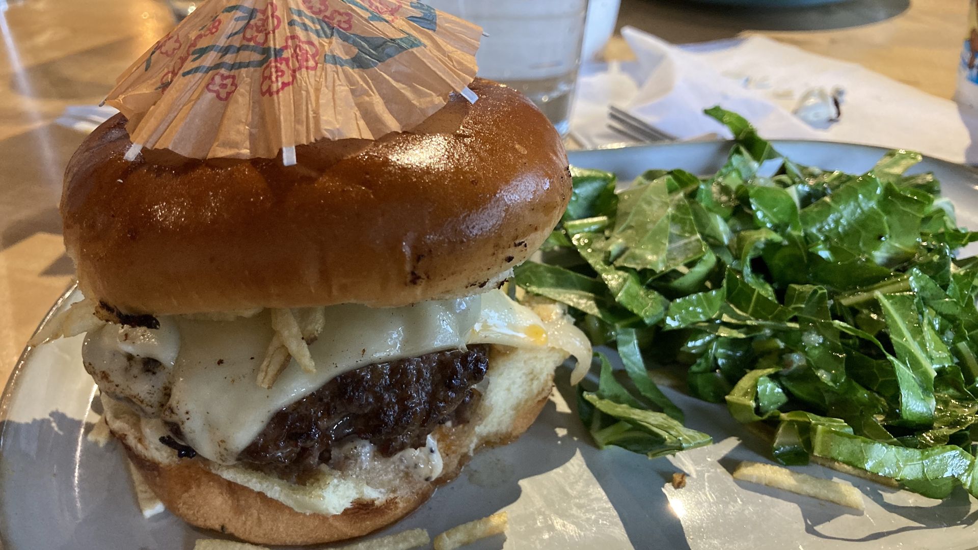 A Cuban burger next to collared greens 
