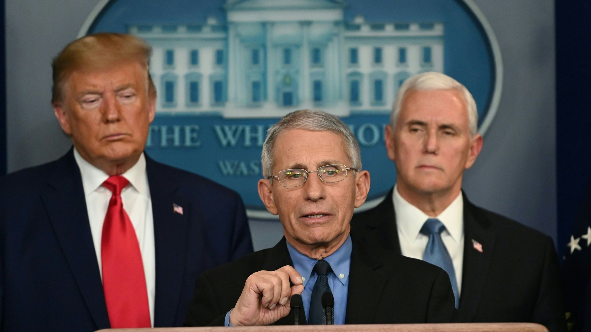 Picture of Anthony Fauci speaking in a press conference in front of Donald Trump and Mike Pence