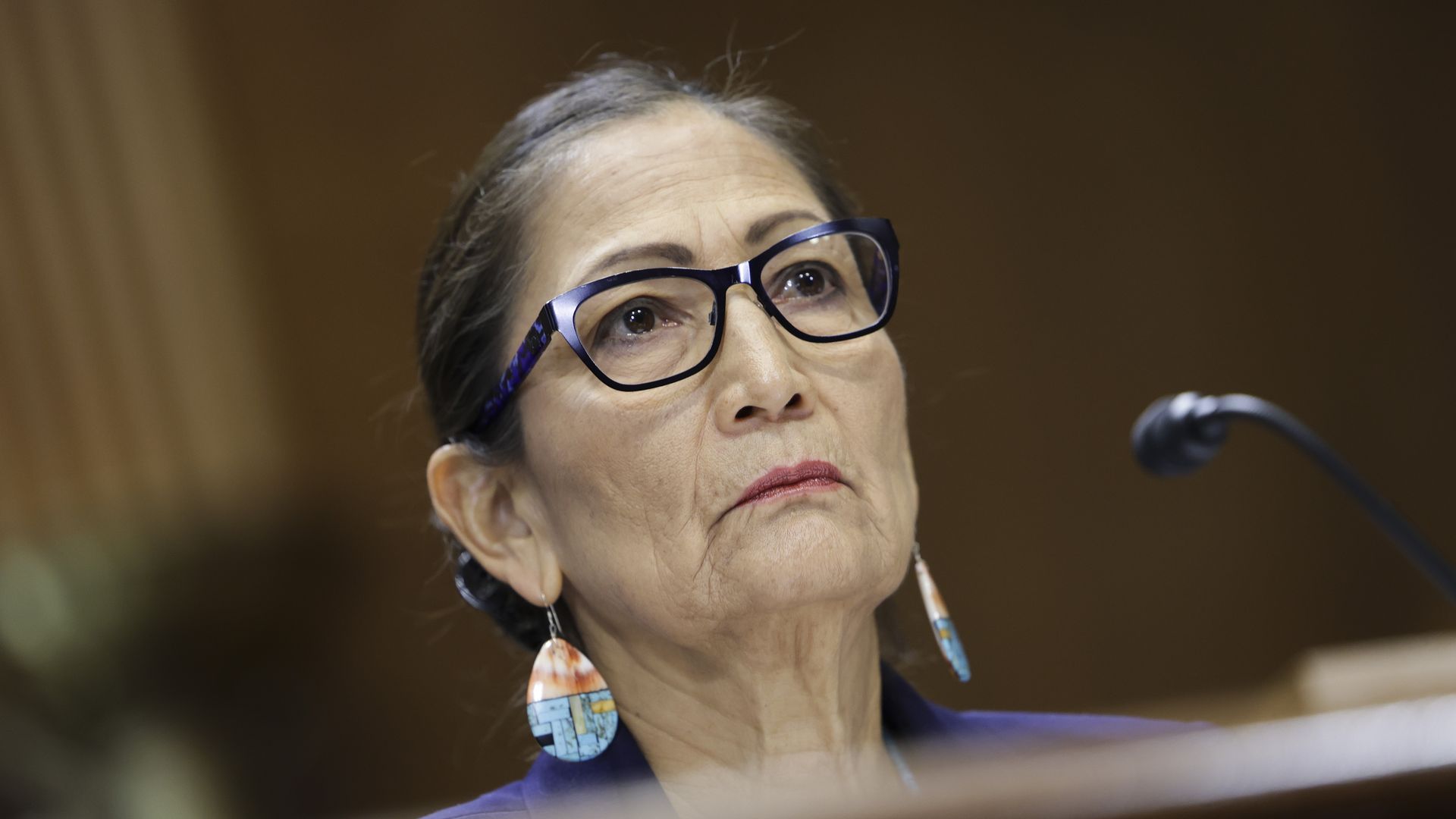 Photo of Deb Haaland in front of a mic