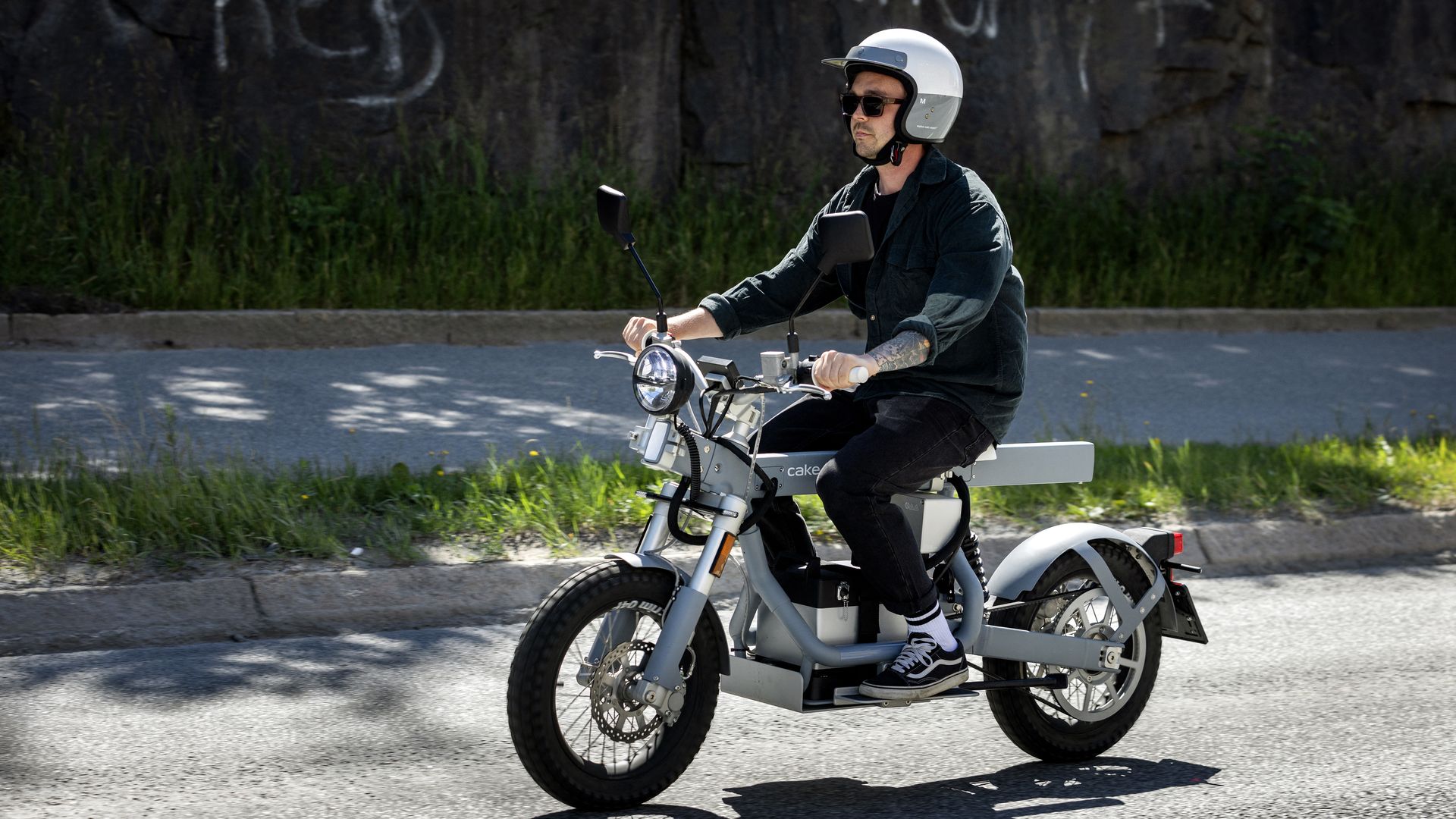 A man sits on an electric motorcycle on the road