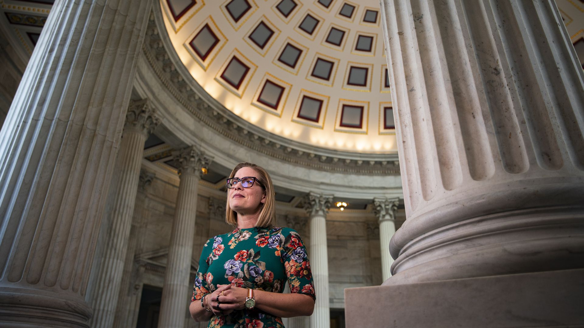 A woman standing in the Capitol rotunda.
