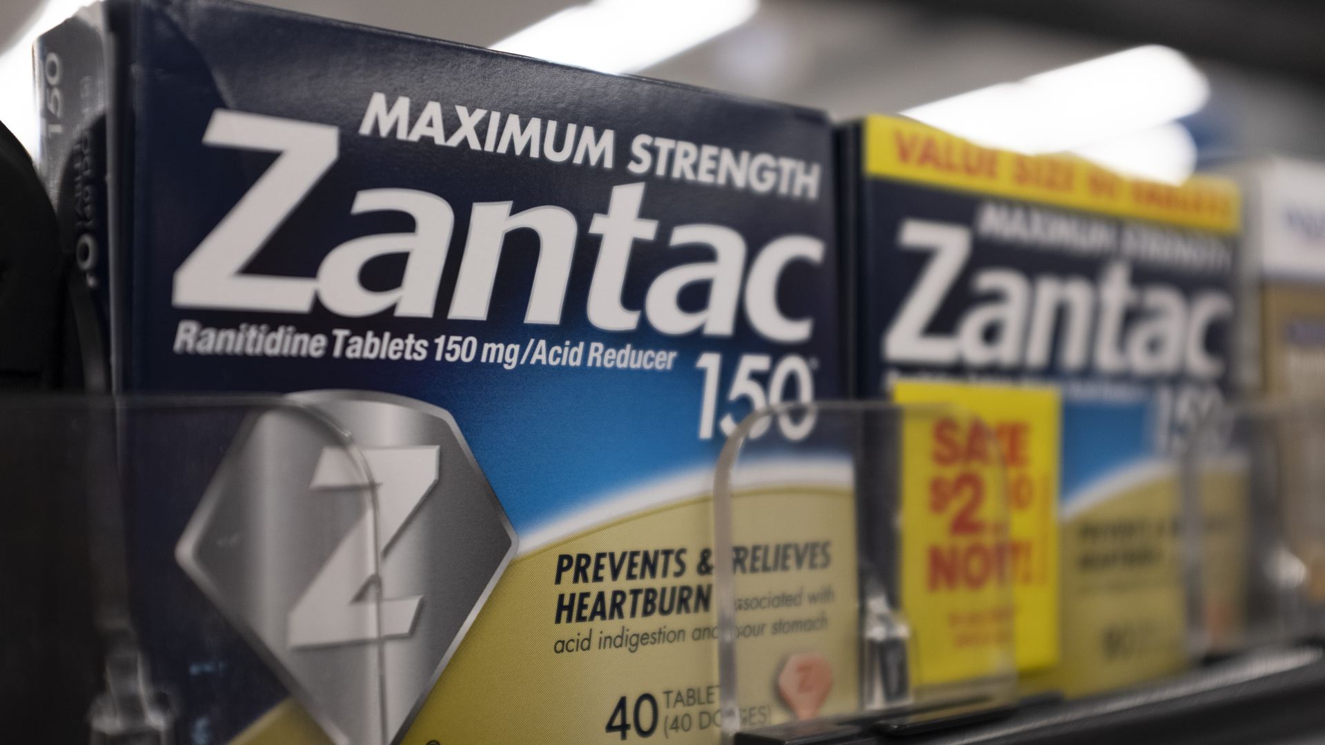 A blue box of Zantac on the shelf of a store.