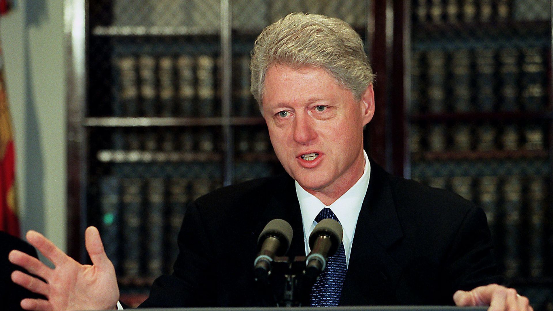 Bill Clinton, former US president, stands behind a podium in 2000