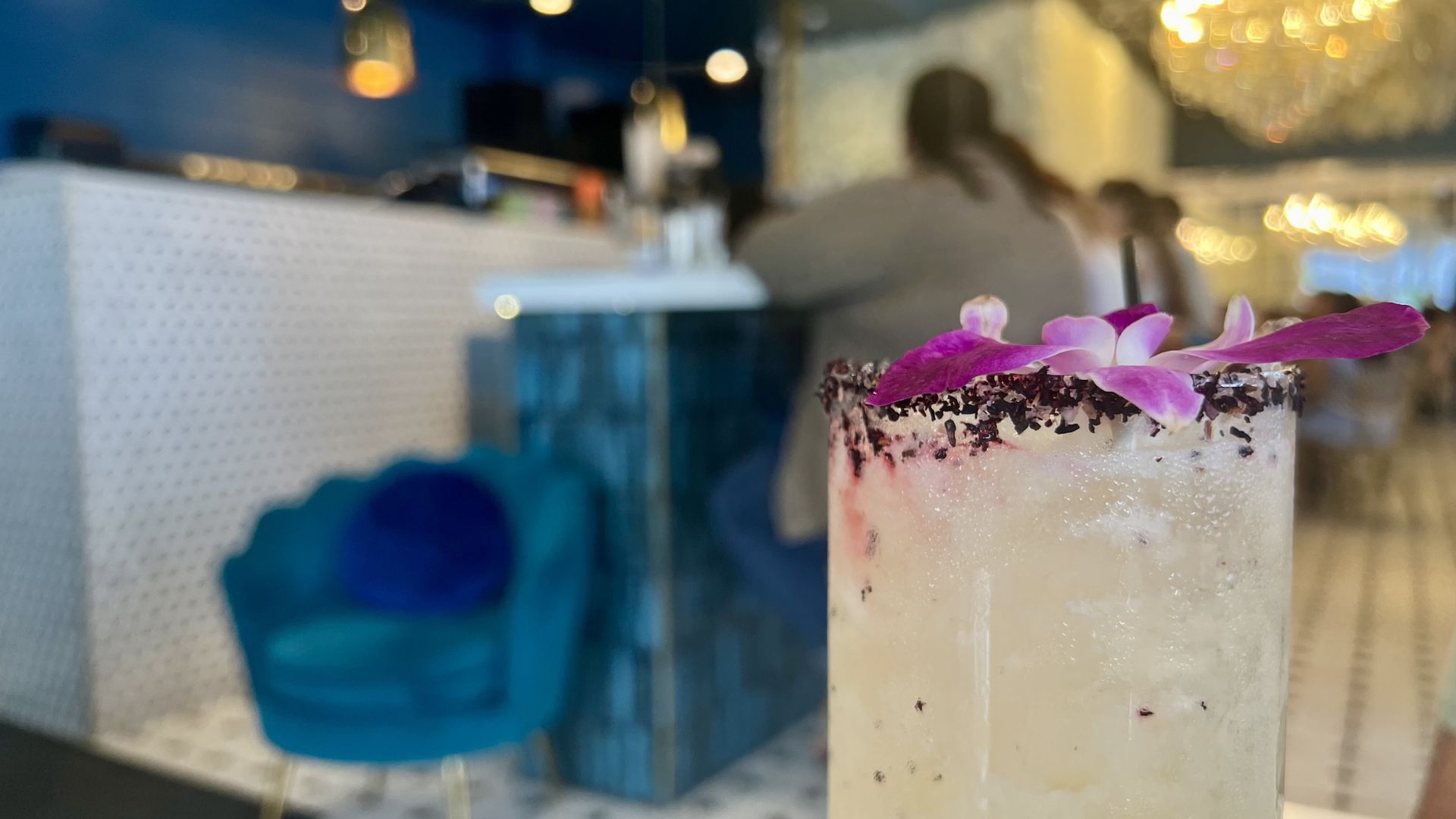 A photo of a cocktail with an orchid on top