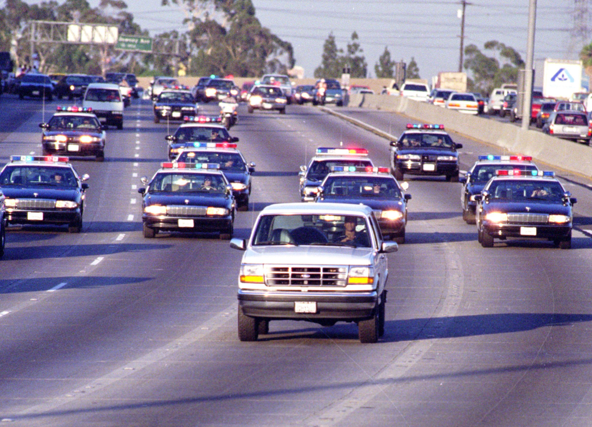 California Highway Patrol chase Al Cowlings, driving, and O.J. Simpson, hiding in rear of a Ford Bronco.