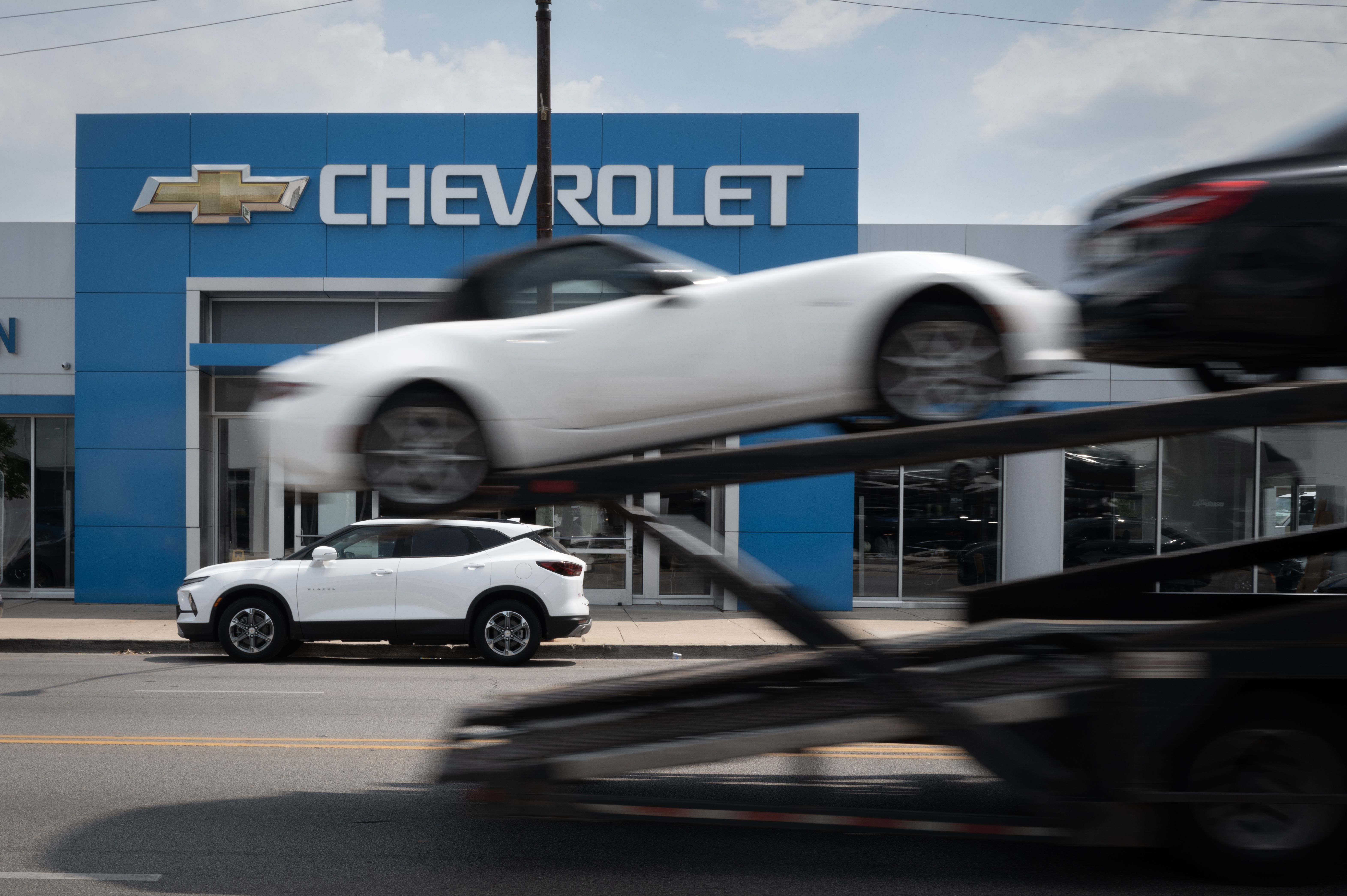 A car hauler passes a Chevrolet dealership in Chicago yesterday