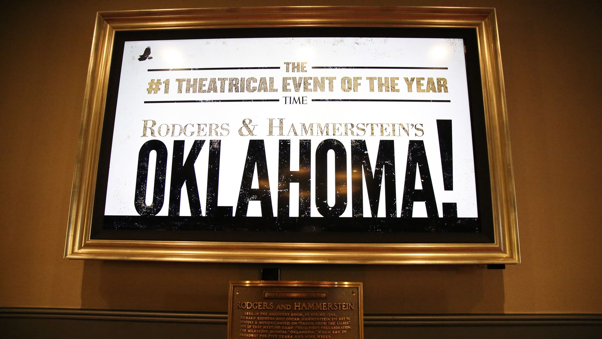 A plaque that reads Rodgers & Hammerstein rests under a display advertising for the Oklahoma! show