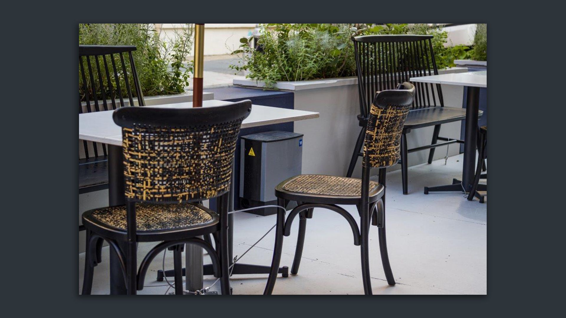 A SMART Box internet-connected rodent trap at an outdoor seating area. 