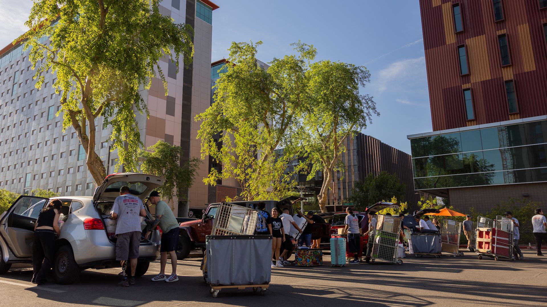 People moving items out of cars.
