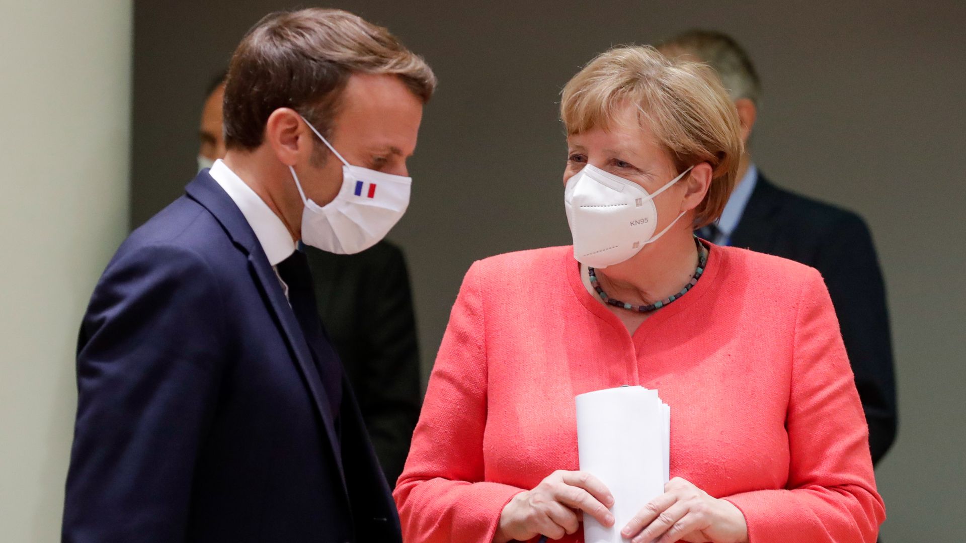 French President Emmanuel Macron (L) and German Chancellor Angela Merkel (R) speak during a last roundtable discussion following a four days European summit 