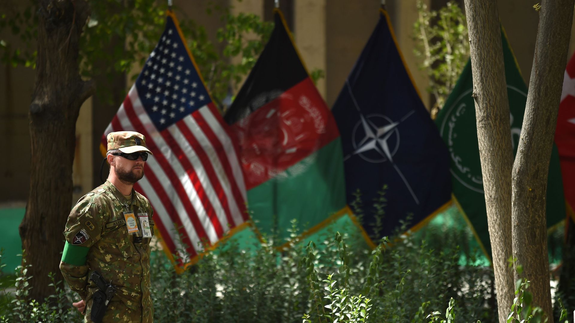 American service member standing next to flags