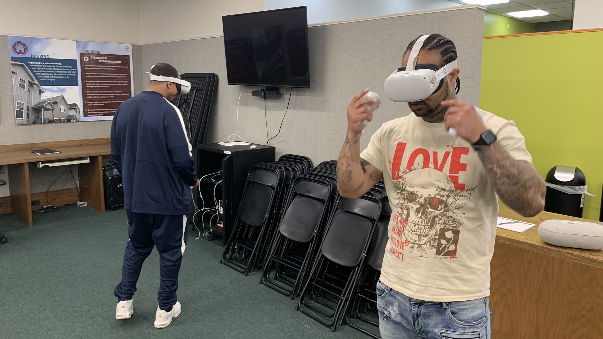 Photo of two people wearing virtual reality headsets in an office 