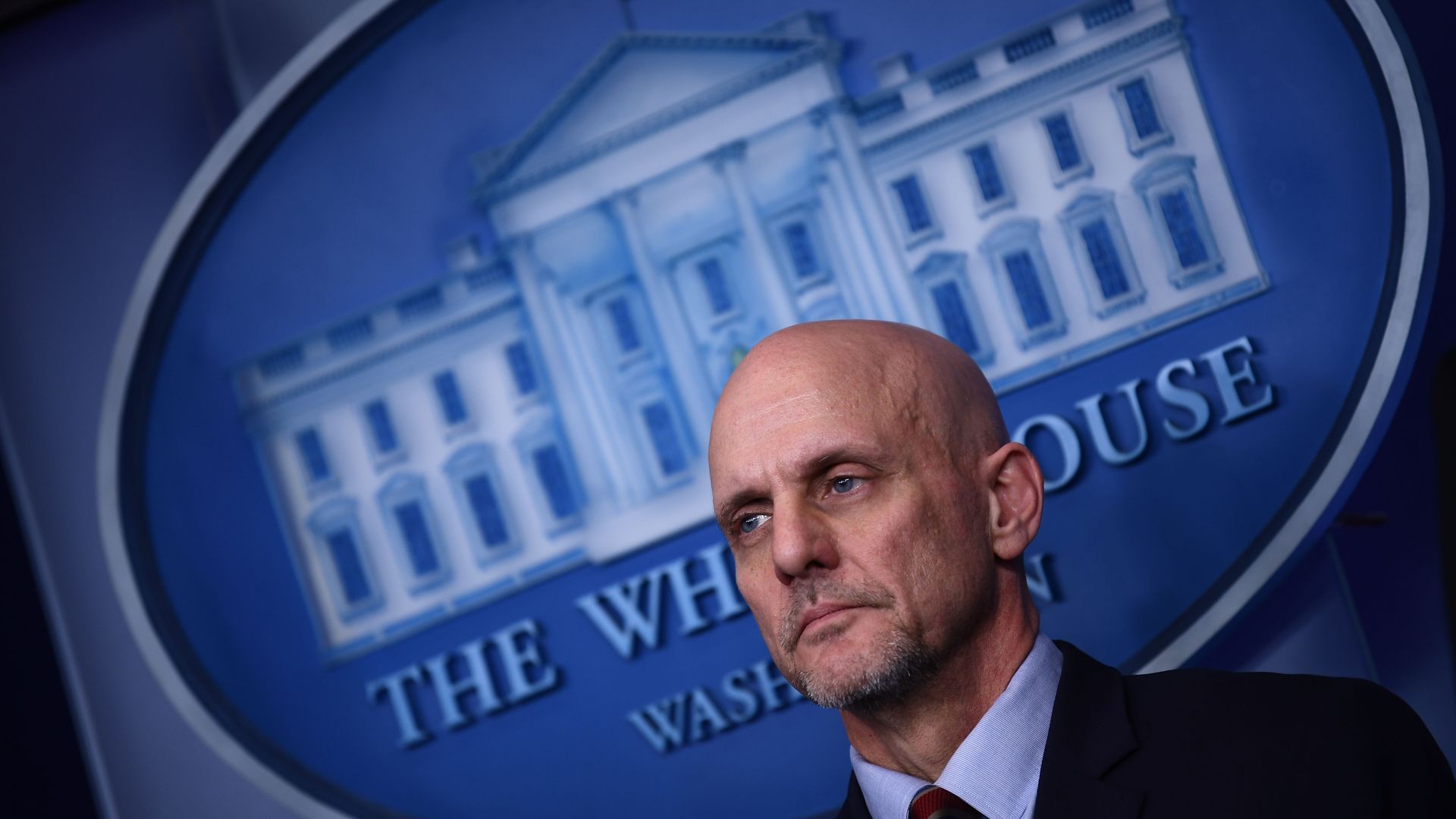 FDA Commissioner stands in front of White House logo 