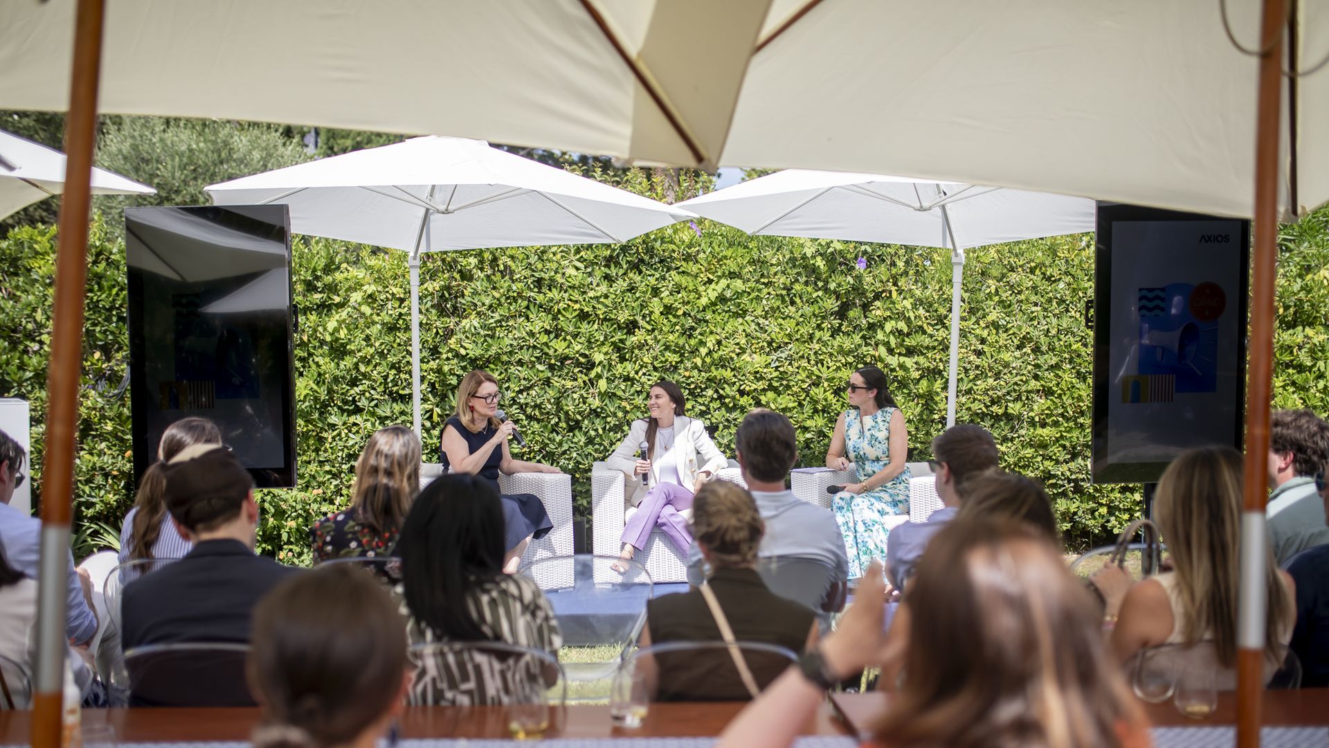 Photo of American Express executives Elizabeth Rutledge and Jennifer Skyler speaking with Axios' Eleanor Hawkins on stage.
