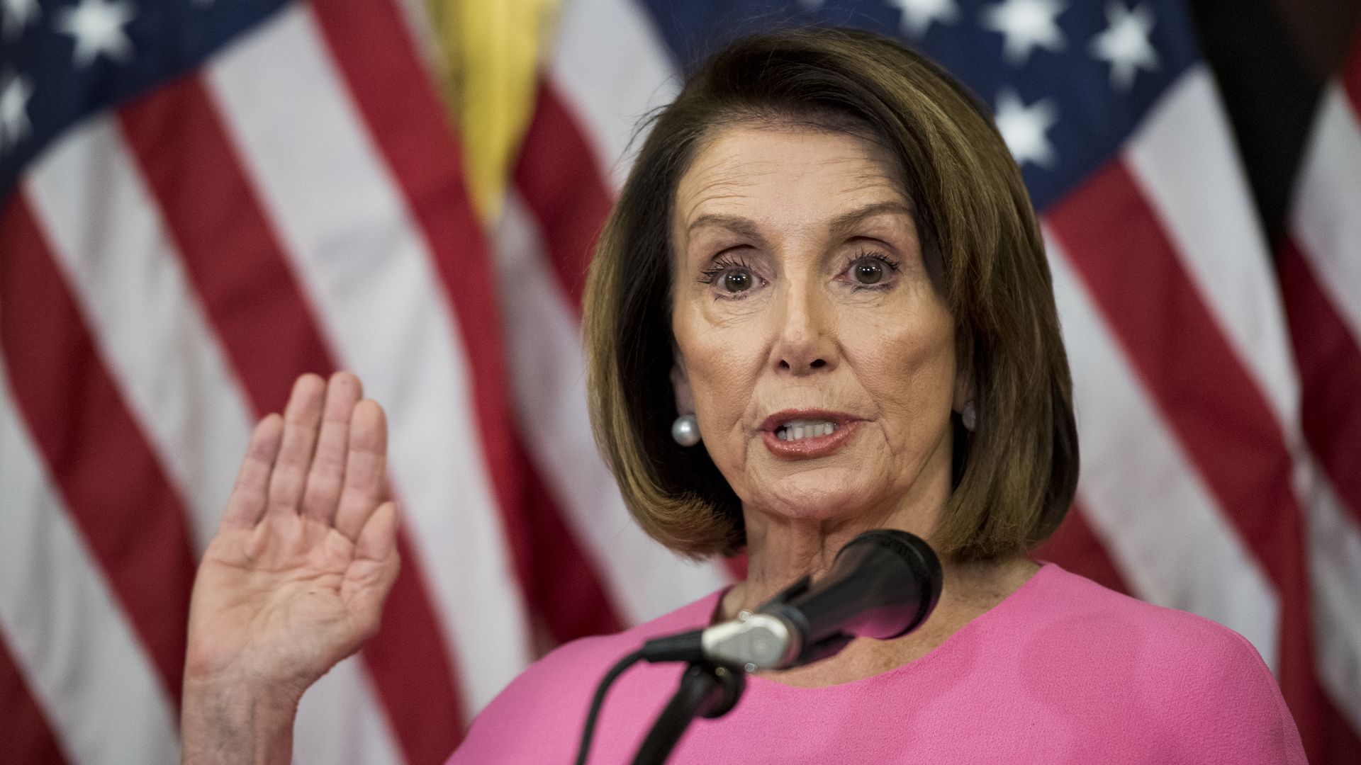 Nancy Pelosi raises her hand as if she's taking the oath of office