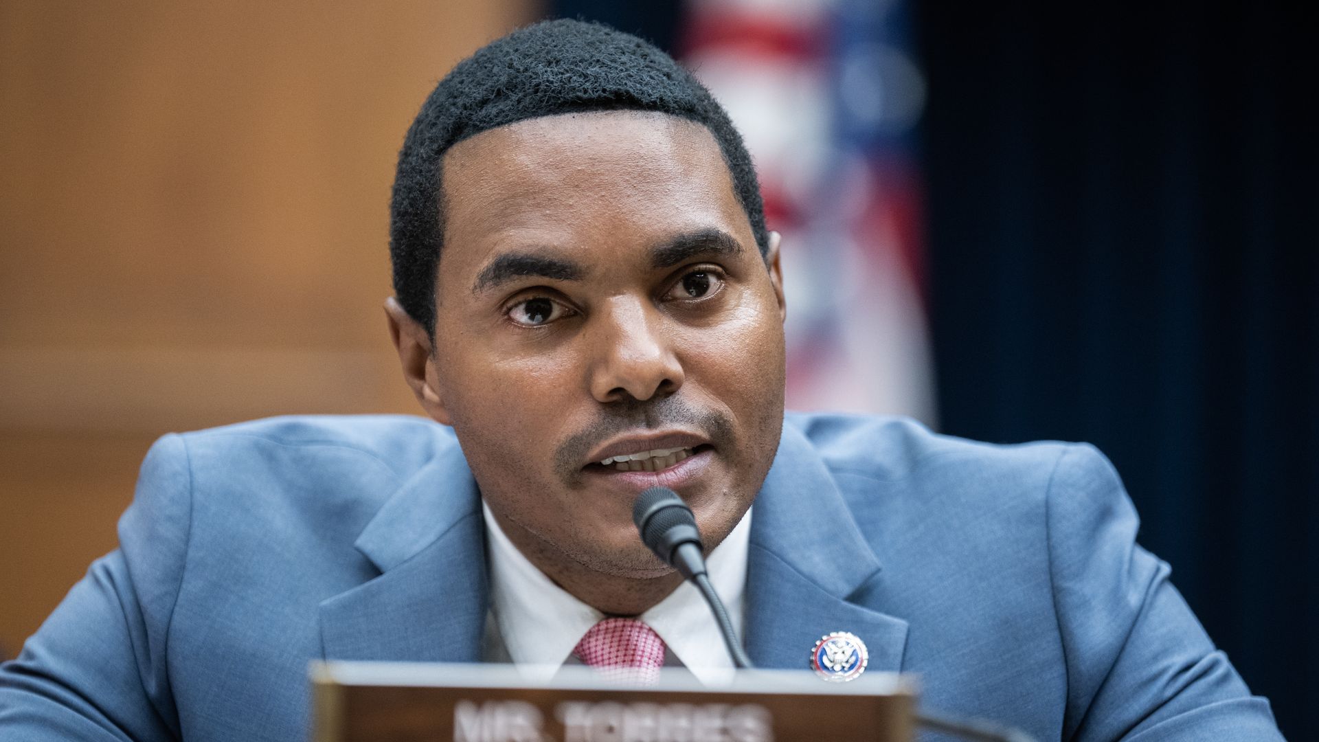 Rep. Ritchie Torres, wearing a blue suit and speaking into a microphone on a committee dais.