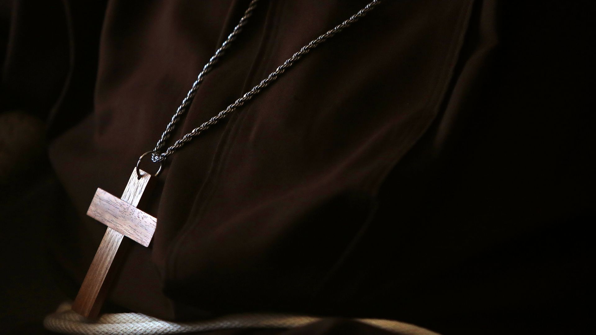 In this image, a wooden cross necklace hangs from a bishop's neck.