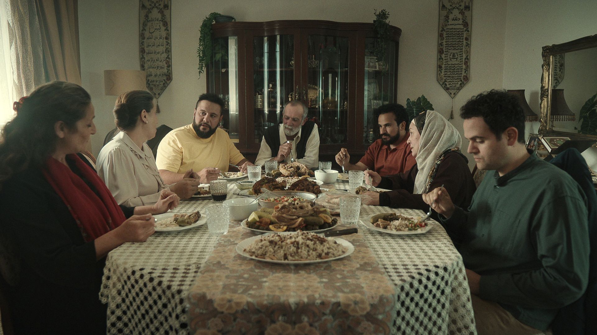 Still from a show where a family is eating a meal together. 