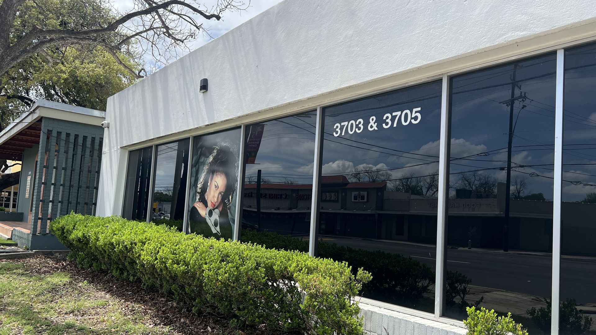 A storefront with a window covered with a photo of Selena.